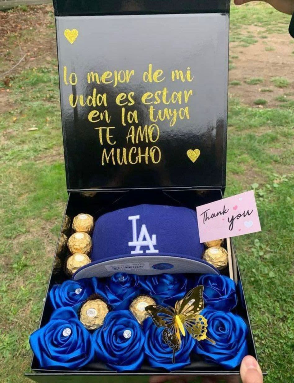 Caja para caballero - Caja elaborada con rosas eternas color azul, mariposas artificiales, chocolates ferrero, y una gorra.