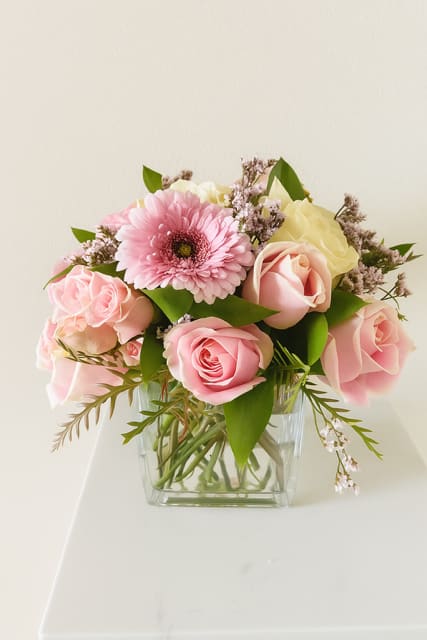Pretty in Pink  - Delicate, charming, and effortlessly elegant- this arrangement of fresh pink blooms is desgined to brighten any space and lift any spirit. Nestled in a modern glass square vase, a hand selected mix of soft pink flowers. 