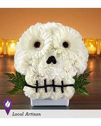 Spooky Skull Flower Arrangement Spooky Skull Flower Arrangement - Make no bones about it… our truly original skull creation will get everyone into the Halloween spirit. Crafted from all-white blooms.