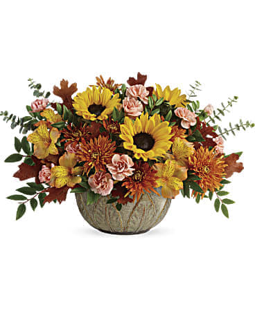 Autumn Sunbeams Centerpiece - Like a ray of autumnal sunshine, this stunning sunflower bouquet brightens everyone's day, especially when they realize it's arranged in a beautifully practical, hand-glazed, oven-to-table stoneware serving bowl! This sunny fall centerpiece features orange roses, yellow alstroemeria, peach miniature carnations, medium yellow sunflowers, bronze cushion spray chrysanthemums, spiral eucalyptus, huckleberry, and brown transparent oak leaves. Delivered in  Artisanal Autumn Bowl. Orientation: All-Around