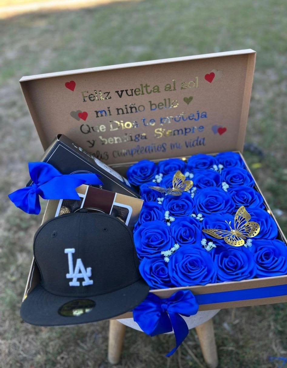 Caja para caballeroo - Caja para caballero elaborada con rosas azules, mariposas artificiales, chocolates ferrero rocher, y una gorra