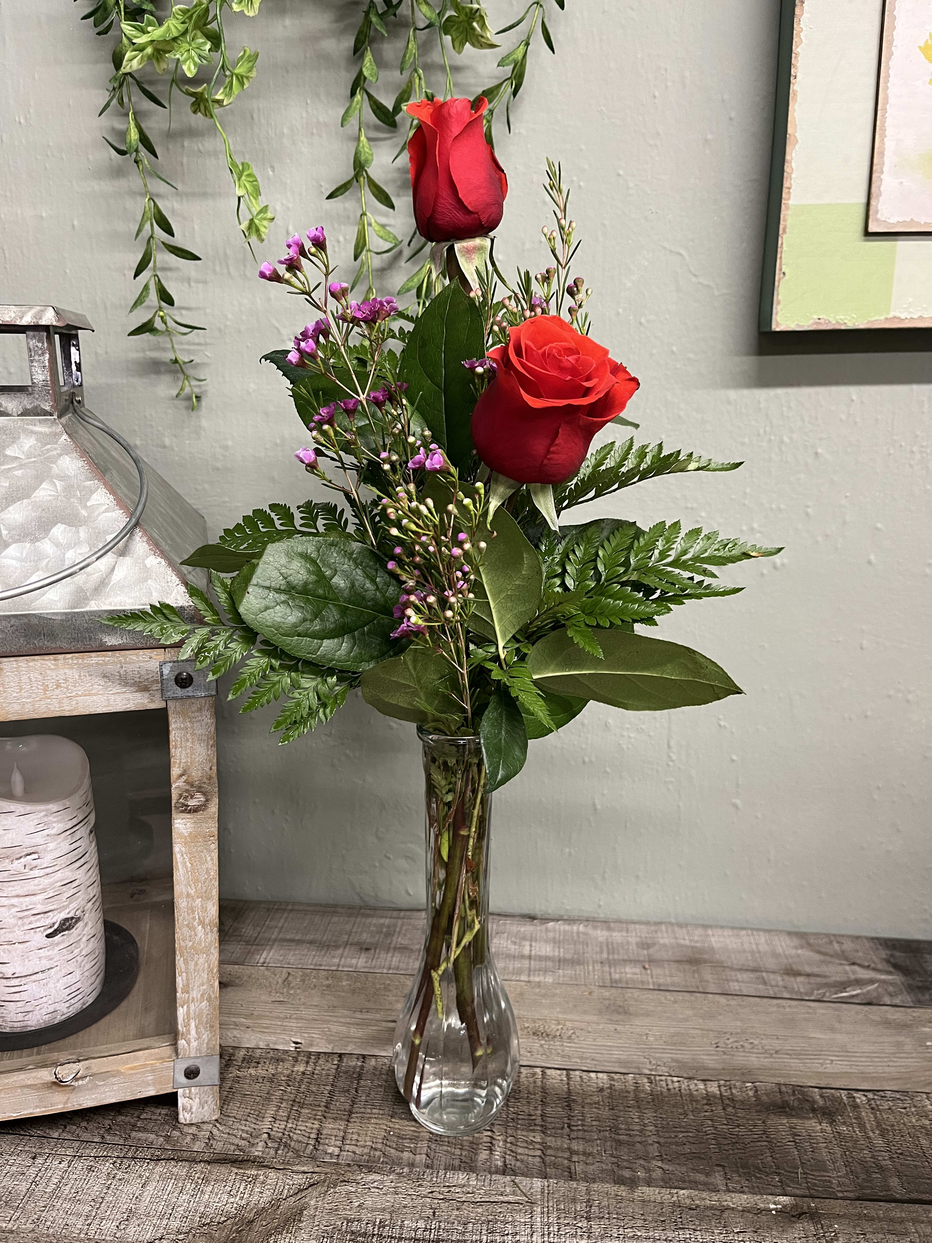 Rose Bud Vase - A simple design with a couple of red roses in a clear vase with filler and greenery. This classic vase says so much in a uncomplicated way. 