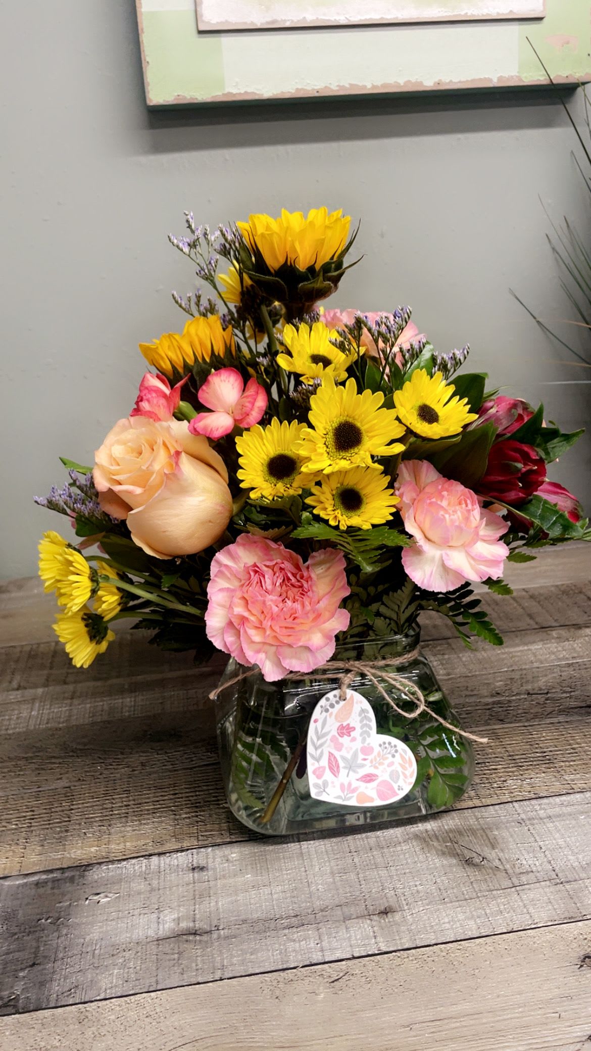 Harvest Heart - This low clear glass vase has a wooden token heart on the front. Show someone you care with this cute arrangement of mixed flowers. This is an all around design.