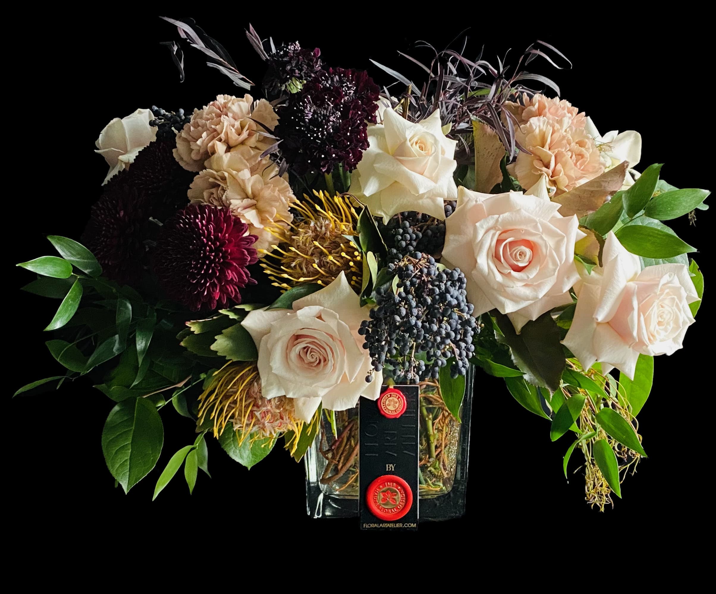Steadfast - Steadfast arrangement consists in a mix of boho toned blooms on a square glass vase with curly.