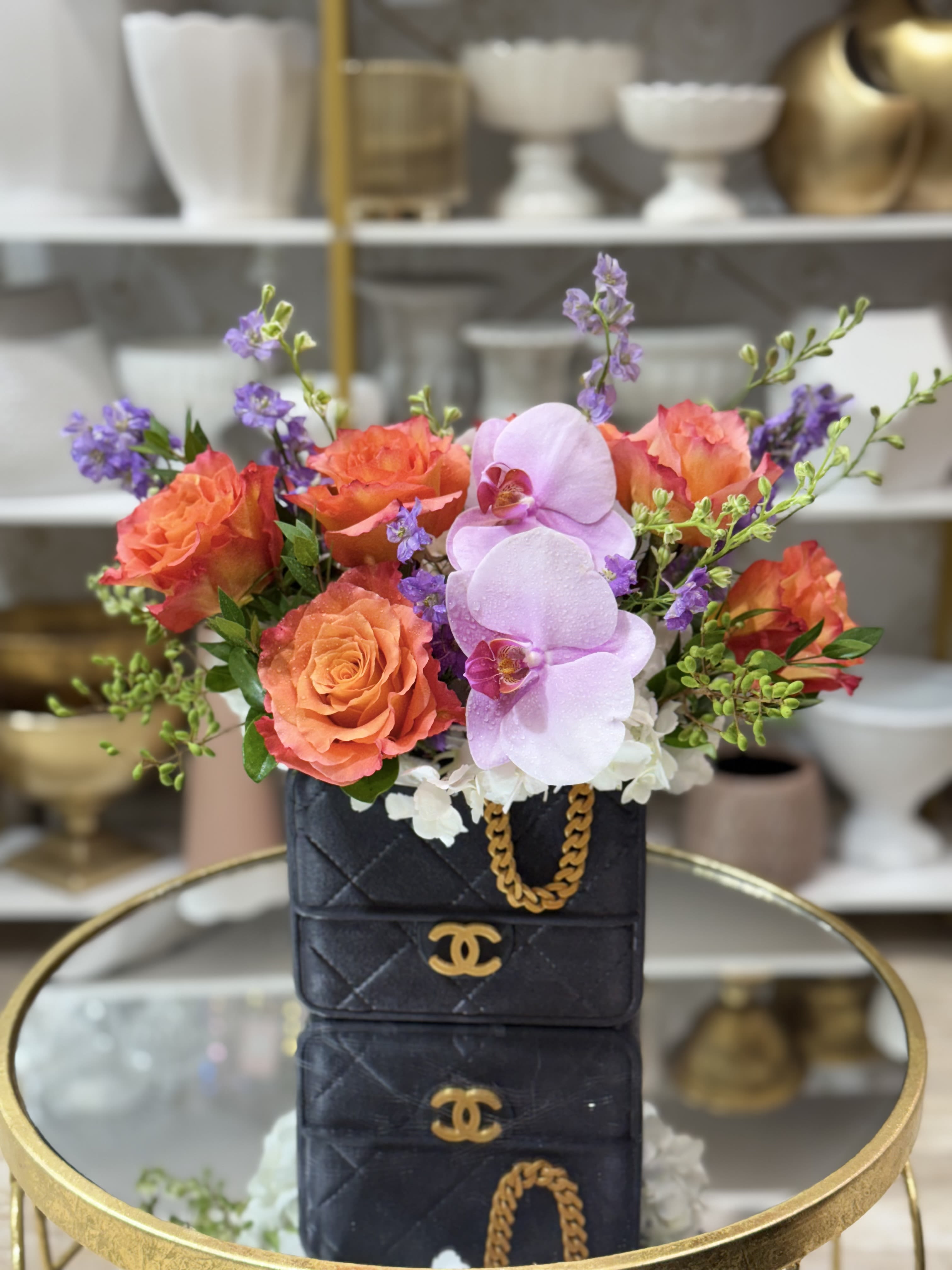Channel Channel - Gorgeous arrangement of roses, orchids and more in a Channel purveyor vase
