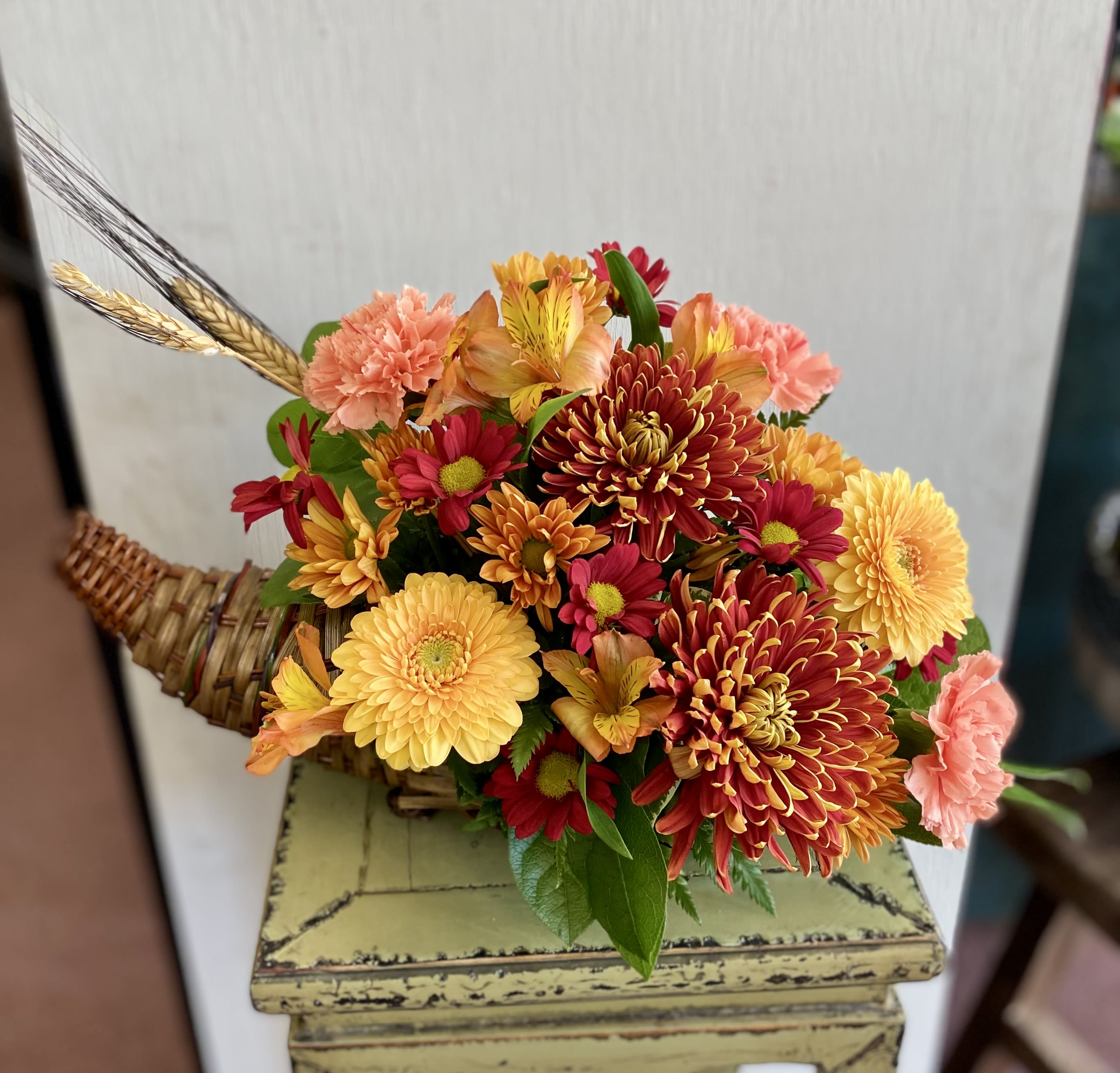 Captivating Cornucopia - This breathtaking array of fall colors and textures is enough to take anyone's breath away. Makes a great Thanksgiving centerpiece or decoration. This year's design includes an array of novelty mums including vyking pomps which mimic the look of a sunflower.