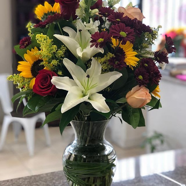 Red and Peach Paradise Red and Peach Paradise - This fancy modern arrangement includes Casa Blanca lilies, Red Roses, Peach Roses, Daisies Solidago and Sunflowers. It is hand delivered in a Rose Vase