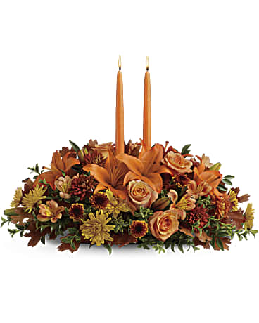 Family Gathering Centerpiece Family Gathering Centerpiece - Graciously gather your family around the warm glow and classic autumn colors of this stunning Thanksgiving centerpiece. A lush variety of burnt orange blooms are gathered under a pair of tall, graceful candles - perfect for decorating your Thanksgiving dinner table, entryway or hearth.