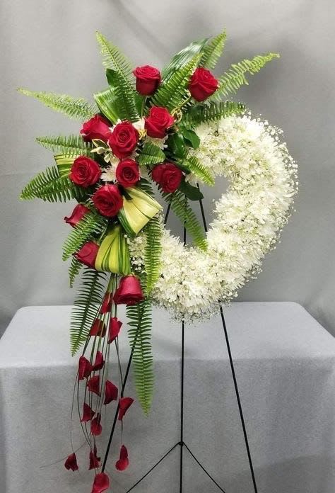 Forever In Our Hearts Forever In Our Hearts - Honor a beautiful life with our Eternal Love Standing Wreath. This elegant tribute combines a lush cascade of classic red roses with a graceful wreath of pure white blooms, symbolizing everlasting love and remembrance. Accented with fresh greenery and presented on a standing easel, this arrangement offers a heartfelt expression of sympathy and respect. Perfect for funeral services or memorial ceremonies, it conveys both love and serenity in a timeless design