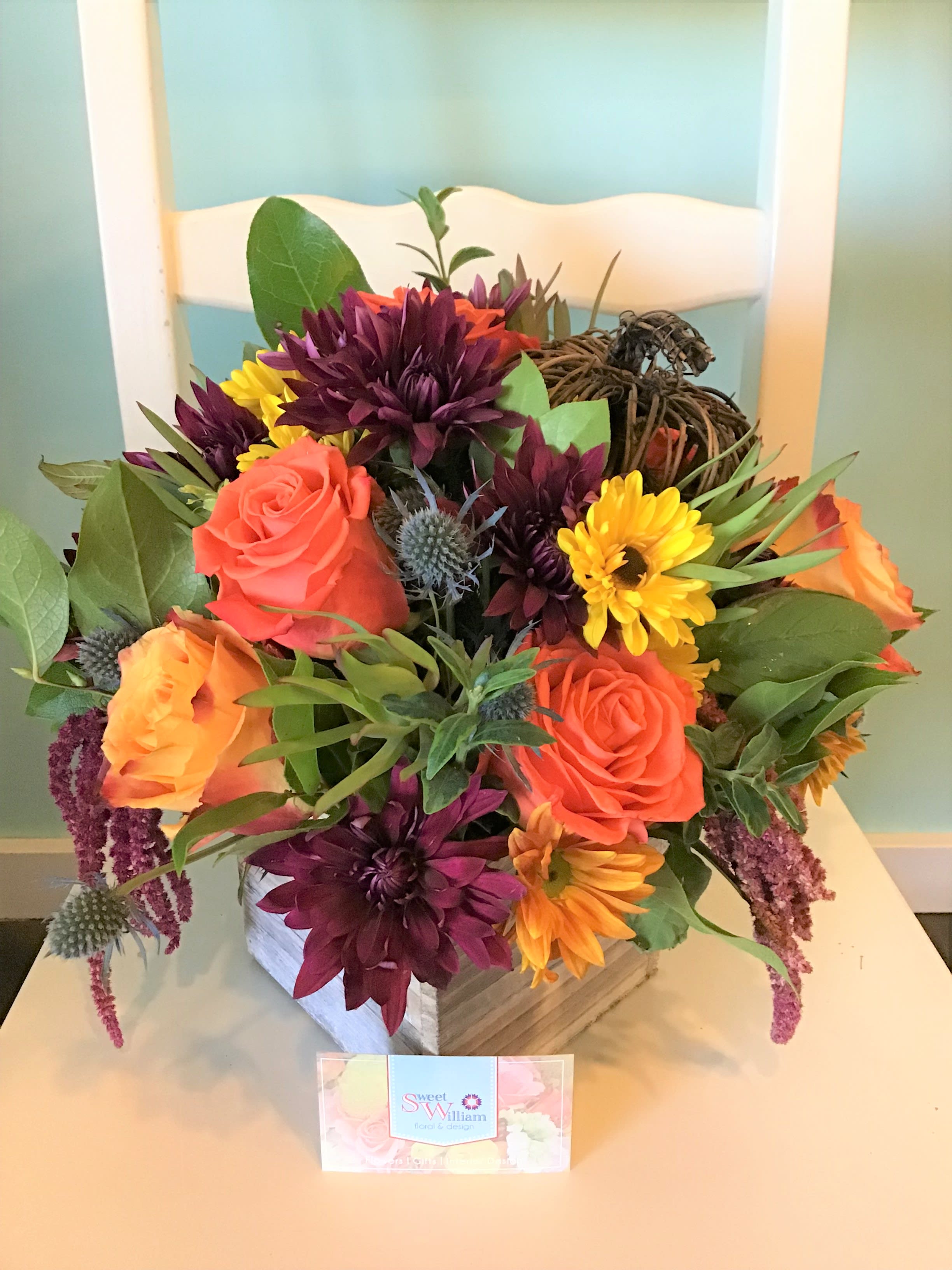 Pumpkin Patch Pumpkin Patch - Nestled within a lovely bed of multi-colored roses, chrysanthemums, and greenery, our little vine pumpkin adds a whimsical charm to this beautiful fall arrangement! Low Profile, sitting approx. 9" tall, this arrangement is perfect for table tops or desk tops. It will warm the heart on these cool fall days!