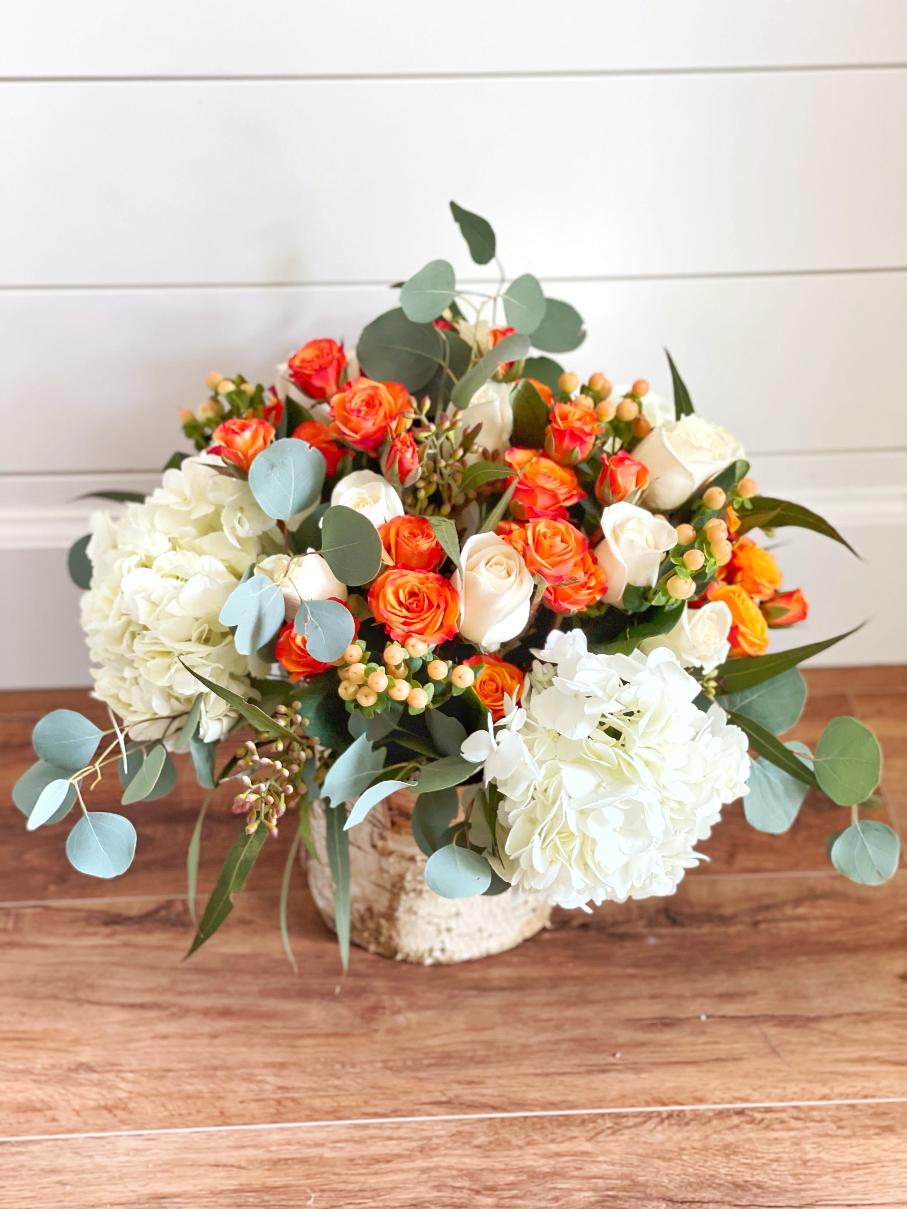 A Pop of Color - White hydrangeas with greenery and roses and other small flowers with a pop of color. 