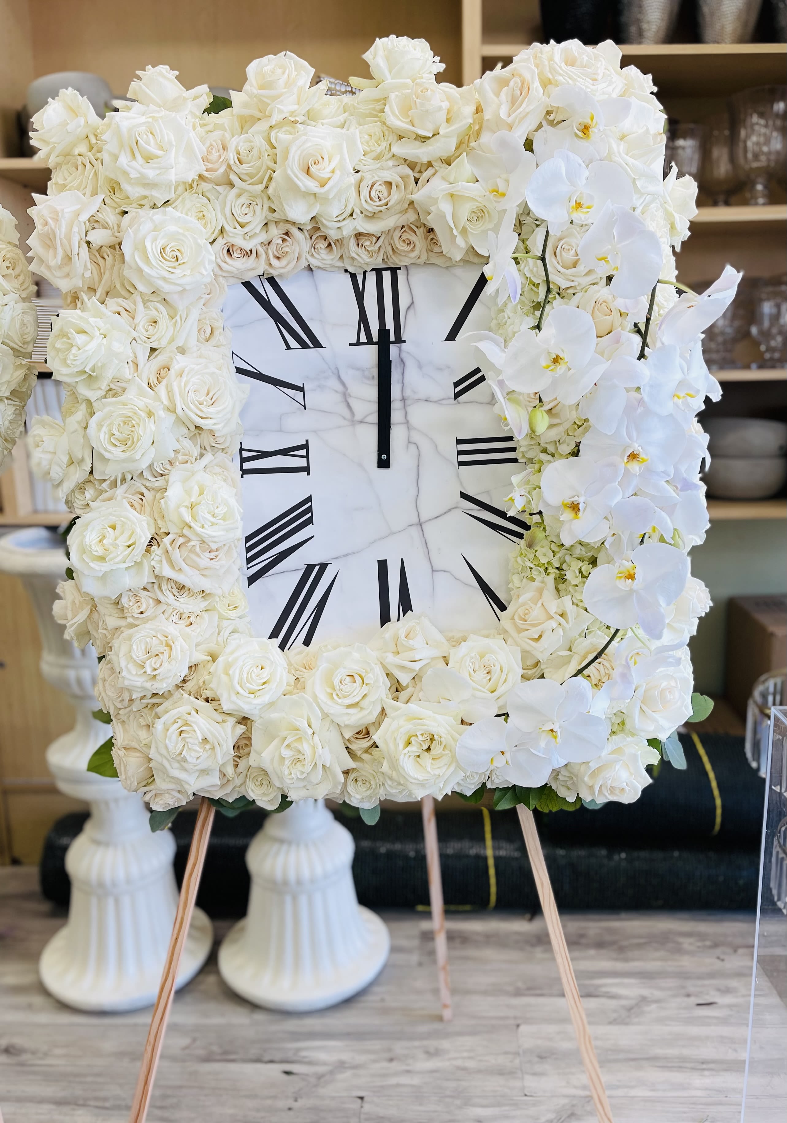 Heaven's Time Heaven's Time - A timeless tribute of fresh white roses and orchids designed in the shape of a clock, symbolizing the preciousness of life and eternal remembrance. Designed in the shape of a clock and displayed on an easel. ️ Requires 4 days advance order. Please provide special instructions for pickup or delivery time.