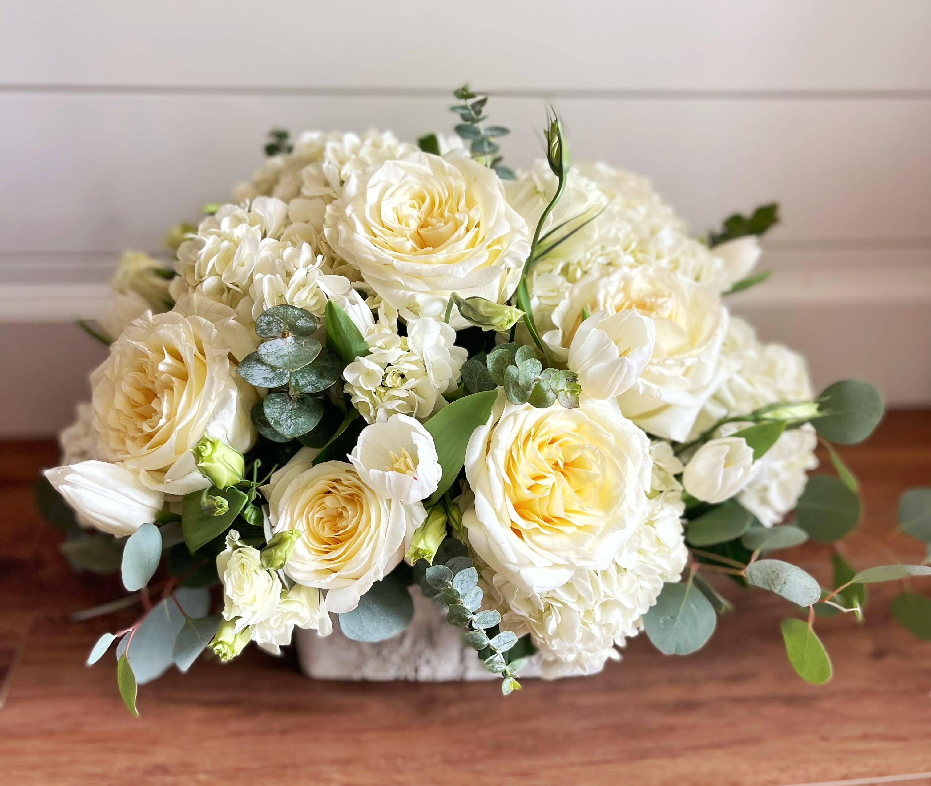 Elegance  - A very elegant arrangement with creams and sage greens of hydrangeas, large roses, Lisianthus, tulips (when white are available) and different varieties of eucalyptus. 