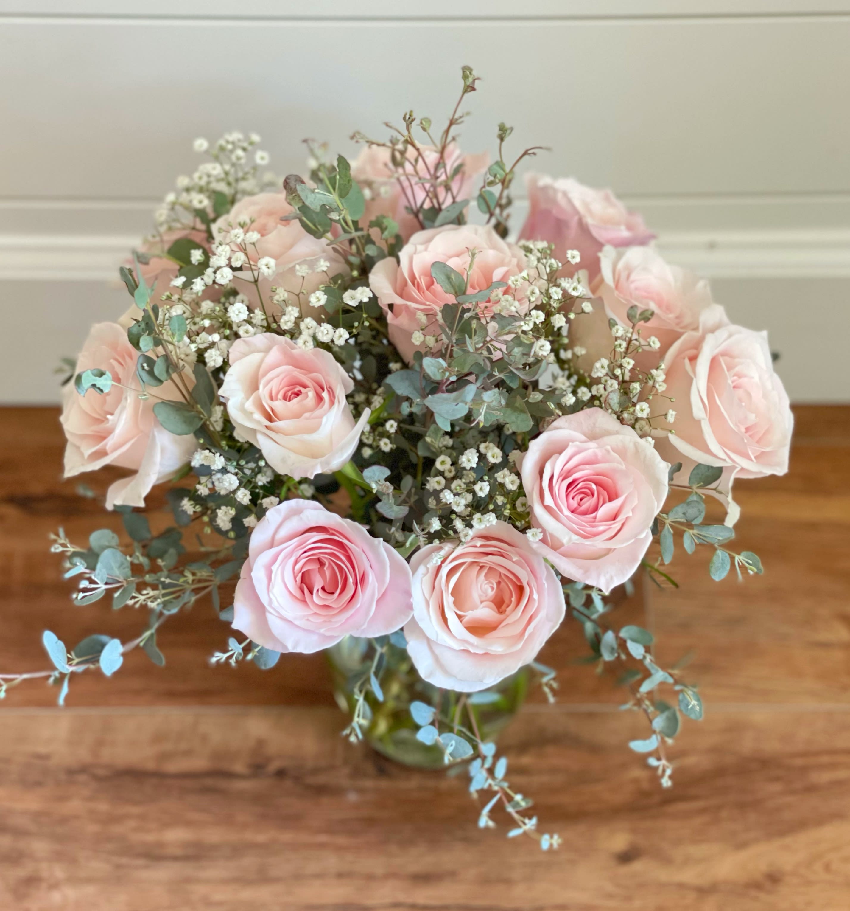 One dozen deluxe  pink roses - One dozen pink roses in a vase with babies breath and eucalyptus. 