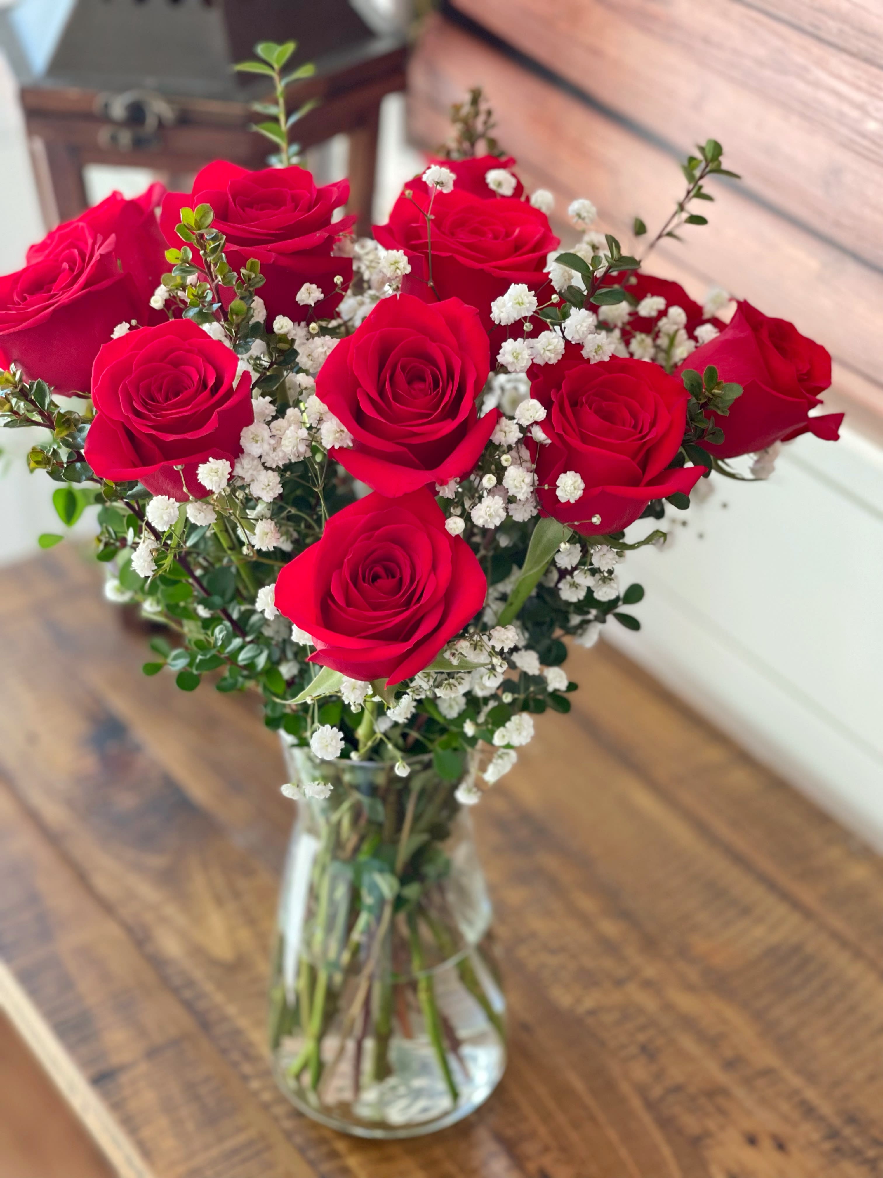 One dozen Red Roses - A charming bouquet of one dozen fresh and fragrant red roses, adorned with just a bit of greenery and babies breath, is a classic Valentine’s Day gift. Delivered in a clear glass vase, this bouquet is also a romantic standard for any day of the year.