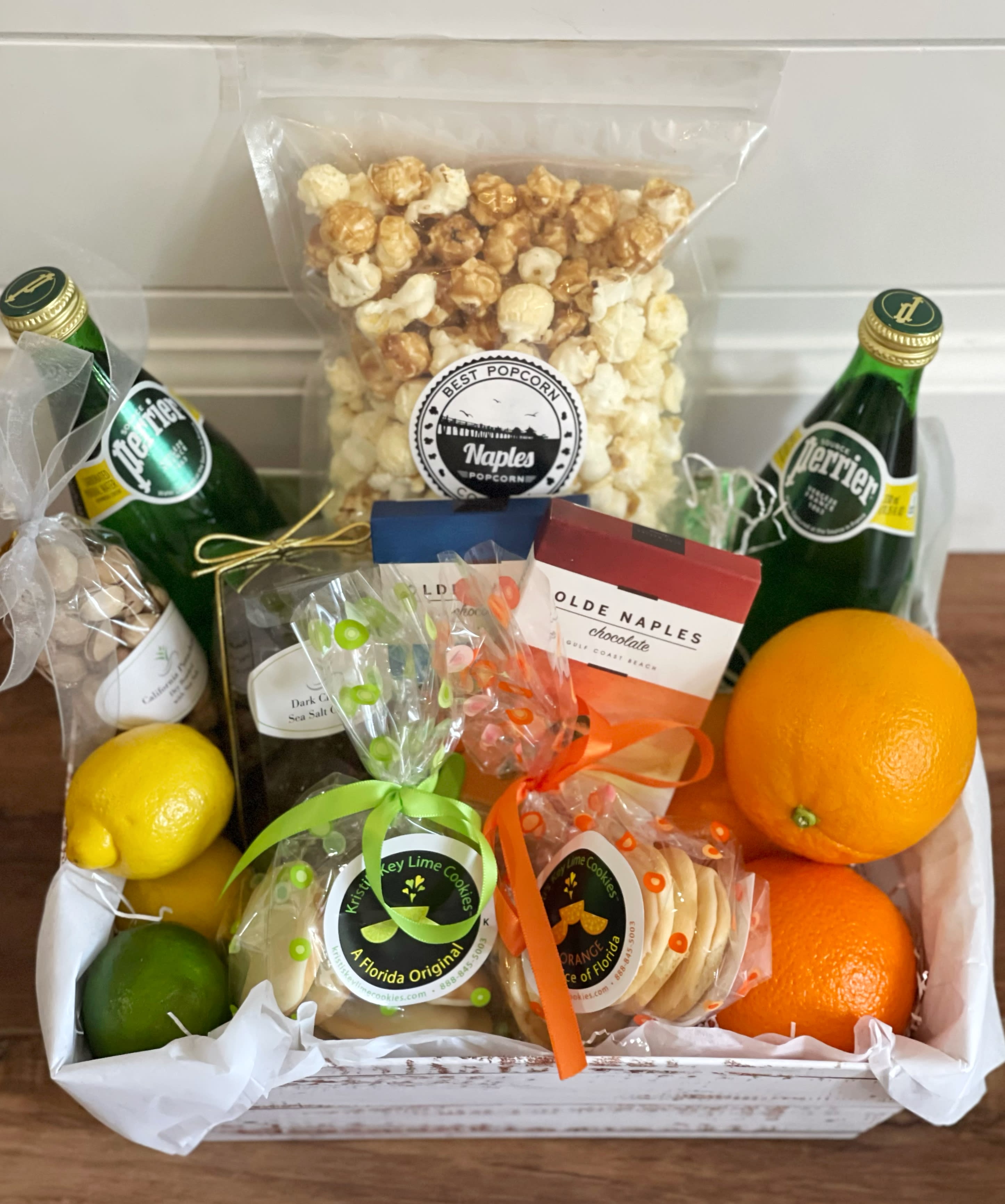 Welcome to Naples - Perfect for treating someone to Naples local favorites. Works great for client appreciation and welcome baskets for vacation rentals. - large bag Naples Mix from Best Popcorn Company (white cheddar &amp; caramel) - 1/4 lb bag of Kristi’s Key Lime Cookies and 1/4 lb bag of her orange cookies (featured in the Daytime EMMY® Awards Swag Bags in Hollywood CA and the News &amp; Documentary Emmy® Award Swag Bags in New York City) -2 bottles of Perrier sparkling water  -fresh lemon, limes and oranges -Dark chocolate sea salt caramels -California pistachios, dry roasted  with sea salt - 2 organic chocolate bars with Naples art work covers from Olde Naples Chocolates. (Milk and dark chocolate with sea salt) 