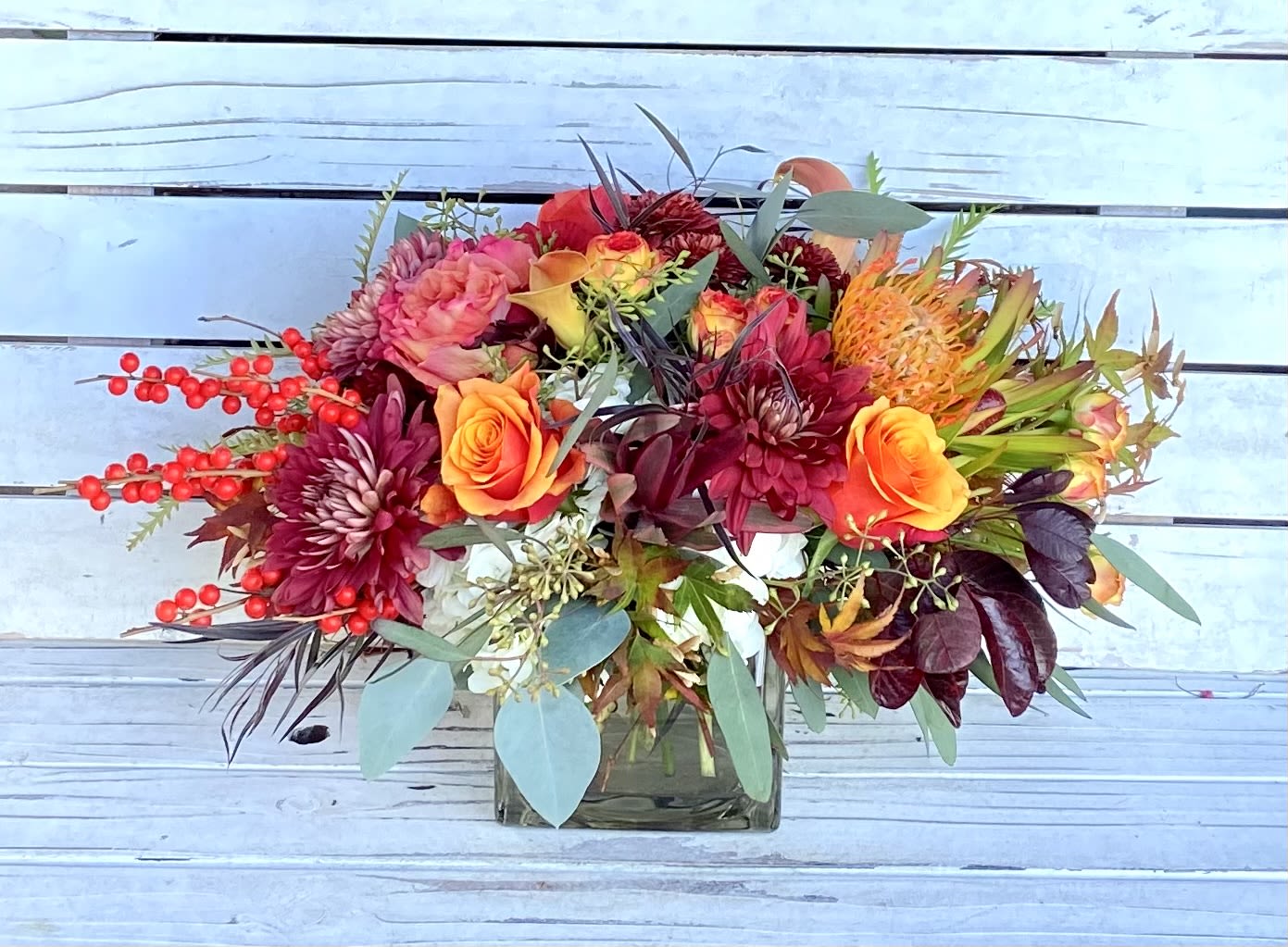 Large Thanksiving Centerpiece  - This festive thanksgiving centerpiece is perfect for a larger dining room table. Comes in a 5x5 glas cube vase. Approximately 11 inches tall and 16-18 inches wide.