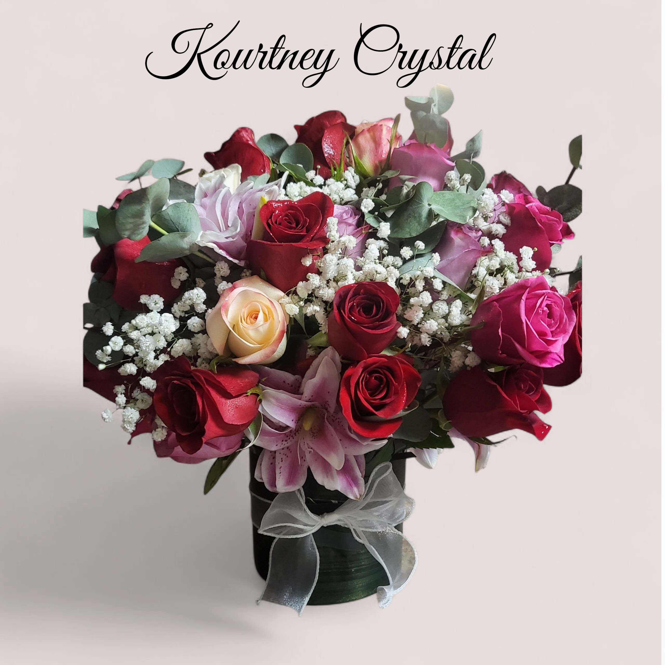 KOURTNEY CRYSTAL KOURTNEY CRYSTAL - A dozen red and pink rose bouquet made with Tea leaves Leather leaf and Baby's breath designed in a glass vase.