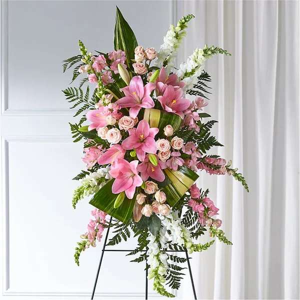 Elegant Embrace Standing Spray Elegant Embrace Standing Spray - Our Elegant Embrace Standing Spray shares the warmth and comfort your loved ones need during this difficult time through each blushing bloom. A local florist beautifully combines lilies, spray roses and snapdragons with greens to express your heartfelt love. Details Approximately 38" L x 22" W Bloom Details Lily Alstroemeria/Peruvian Lily Snapdragon