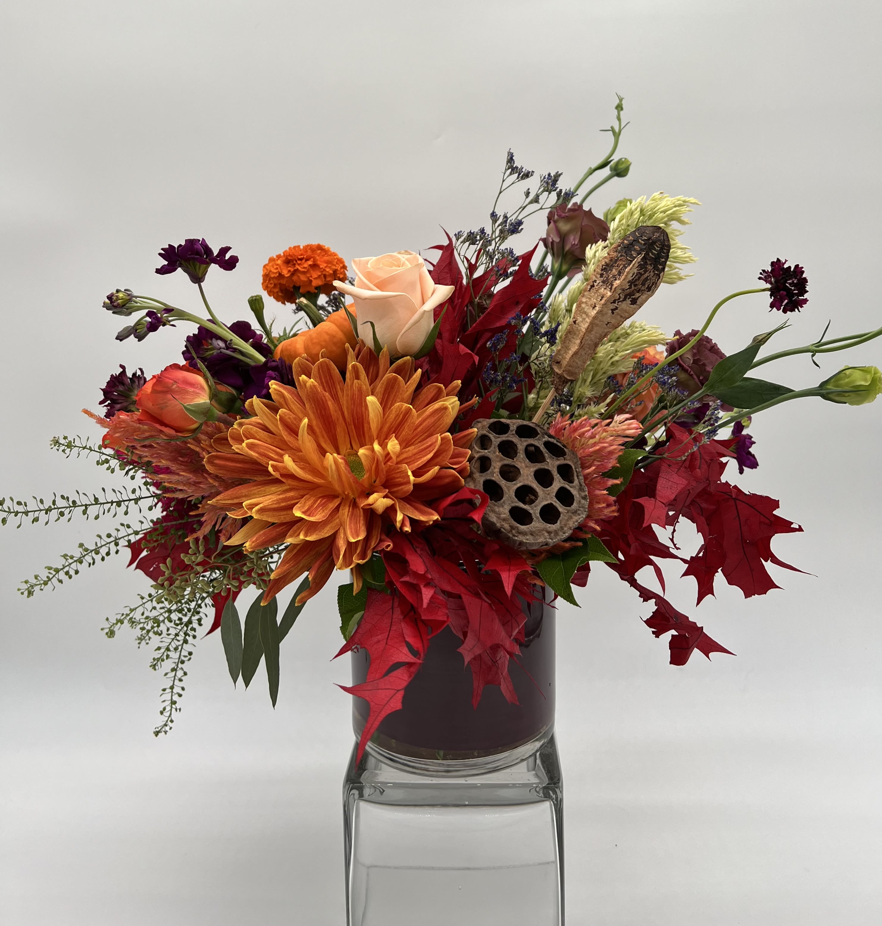 Wicked Game - Fall inspired arrangement with spooky, dark tones. Arrangement contains a pumpkin, cones, and an array of seasonal flowers!