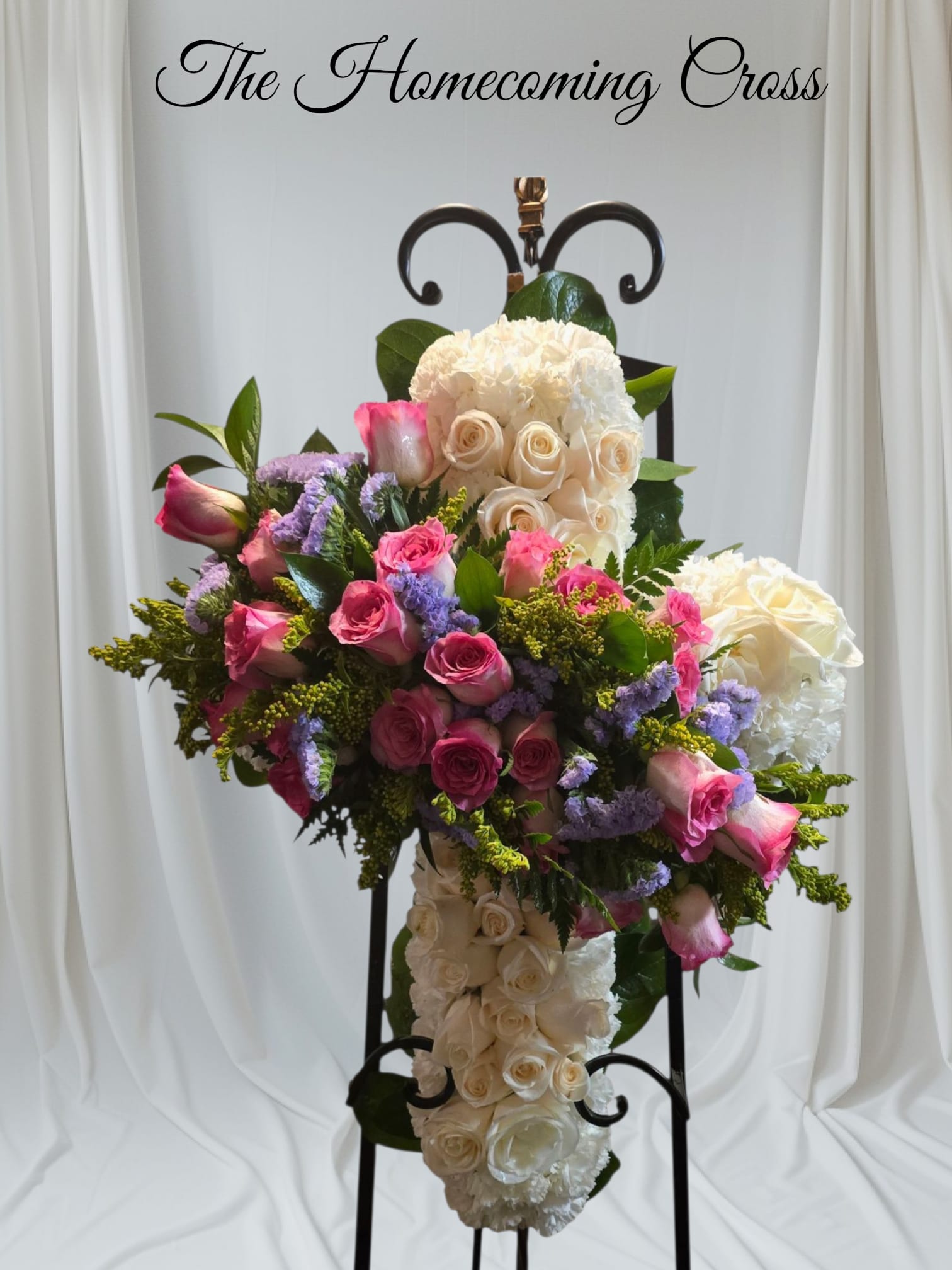 THE HOMECOMING CROSS - A beautiful Memorial cross made with White and pink roses, white carnations, lemon leaf and leather leaf and solidarity filler.