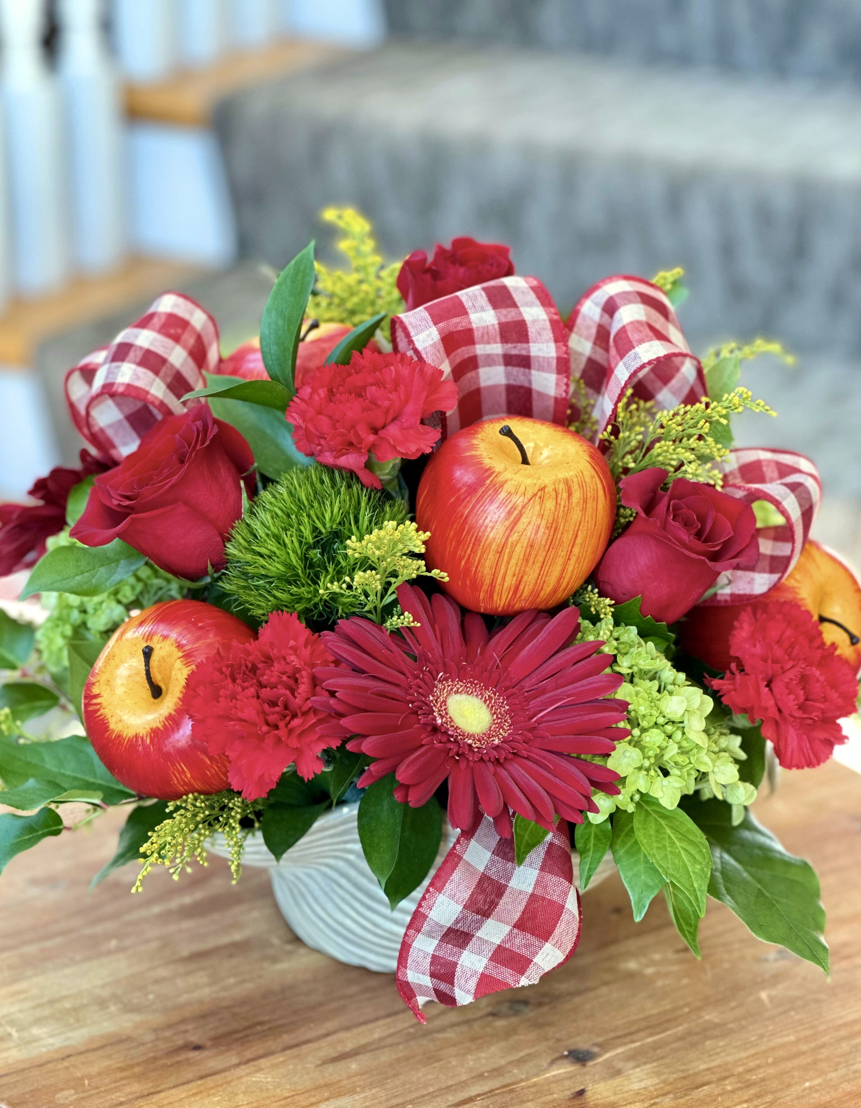 Apple Season Apple Season - FALL COLLECTION | LOCAL DELIVERY ONLY A playful nod to harvest season, this arrangement features lifelike apples tucked among gerbera daisies, hydrangea, trick, solidago, roses and fall ribbon. Designed in a modern keepsake container, it blends rich textures, and vibrant fall tones for a centerpiece that feels both fresh and festive.