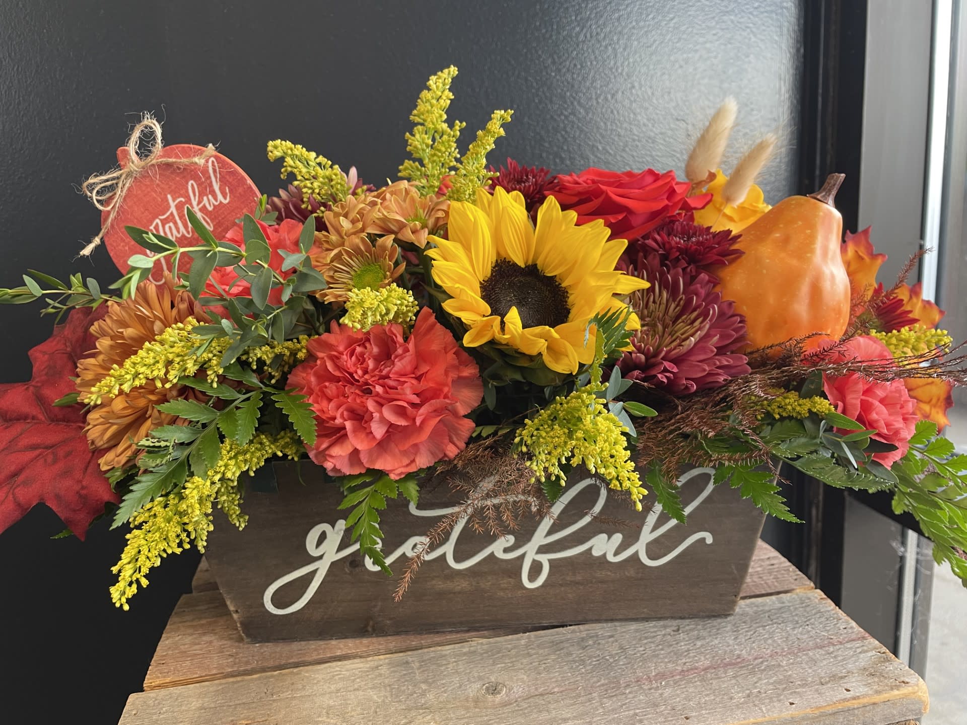Grateful Harvest  - No dinner party or food gathering is complete without a centerpiece and this large arrangement makes a big statement on any table. Featuring a variety of autumn flowers, dress up any event with this arrangement. Send it as a housewarming or thank you gift.   
