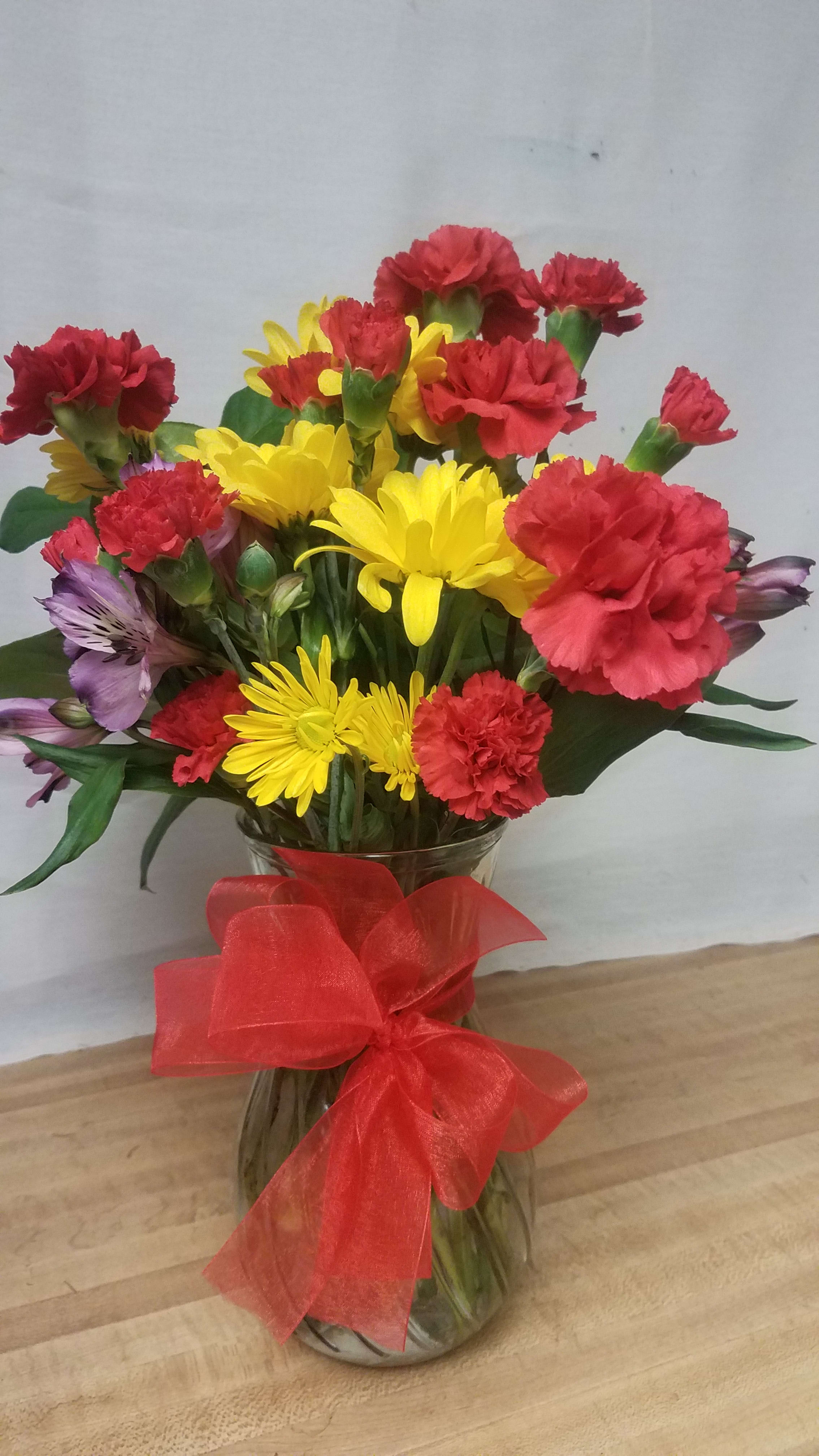 Primary Fall Primary Fall - The bold colors of red, yellow, and purple are displayed in this bright vase arrangement of long-lasting carnations and alstromeria.