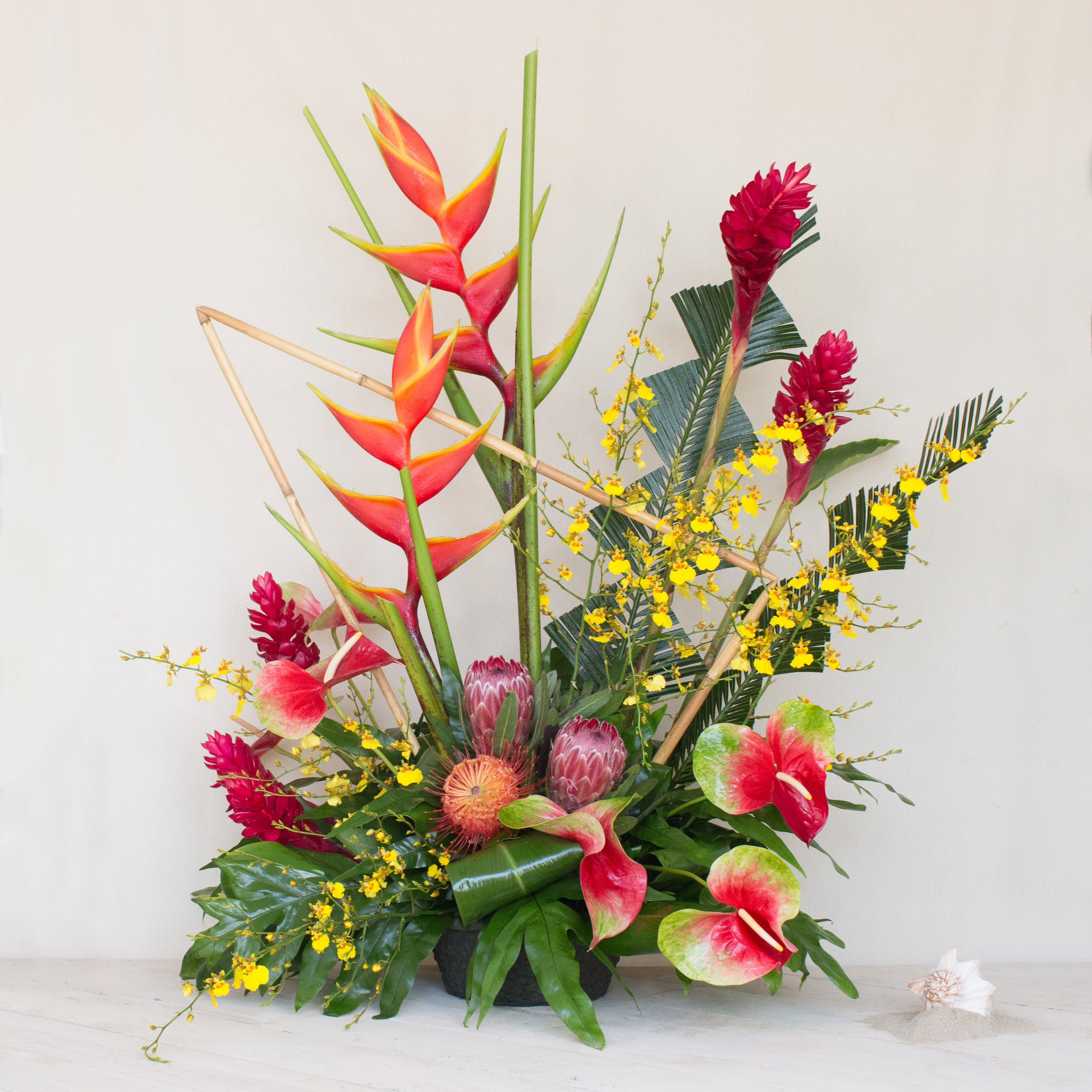 Tropical Melange (Grand Openings)  - Ideal for a Grand Opening or to impress a new, important client, our grand tropical floral arrangement stands approximately 40 inches tall by 36 inches wide. This stunning piece is filled with an assortment of locally grown tropical flowers, creating an amazing display of natural beauty and elegance.  Key Features:  Grand Size: Measures approximately 40 inches in height and 36 inches in width, making it a substantial and impressive arrangement.  Locally Grown Tropical Flowers: Features a vibrant assortment of locally sourced tropical flowers, showcasing the rich diversity and beauty of the region.  Perfect for Special Occasions: Ideal for grand openings, corporate events, or as a prestigious gift for an important client, conveying warmth and appreciation.  Impressive Presentation: Designed to make a lasting impression with its breathtaking display of exotic blooms and lush greens.  Handcrafted Excellence: Expertly handcrafted by our skilled floral designers to ensure a flawless and stunning arrangement.  Elevate your special occasion with our Grand Tropical Floral Arrangement, and let its beauty and grandeur speak volumes, setting the perfect tone for celebration and admiration.       