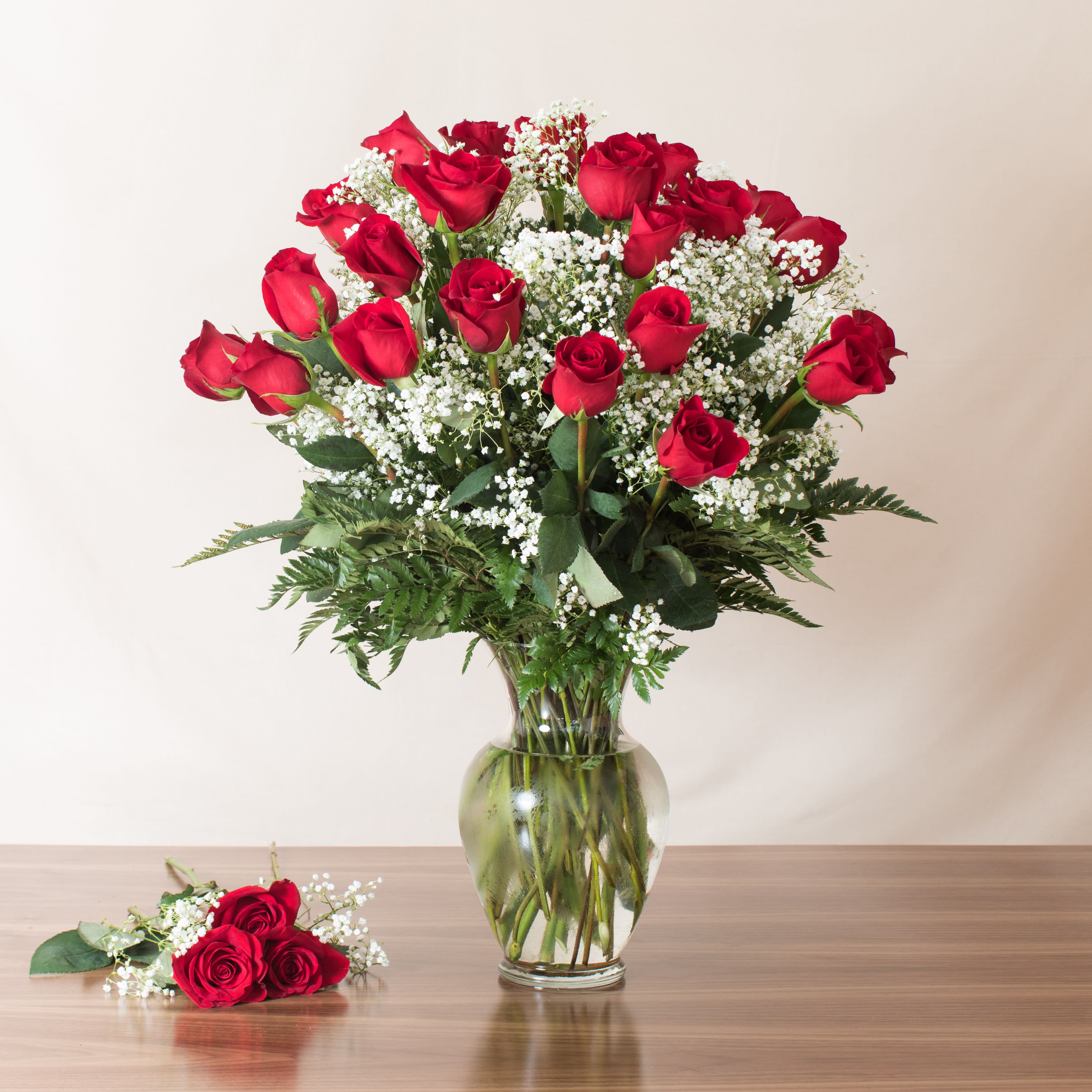 2 Dozen Red Masterpiece (Premium Roses)  - Indulge in the luxury of 2 dozen premium South American long stem roses in this gorgeous bouquet! This full and beautiful arrangement is meticulously accented with gorgeous greens to enhance the natural beauty of each rose.    Key Features:    Premium Quality Roses: Each bouquet features 24 long stem roses sourced from South America, renowned for their exceptional quality and vibrant colors.    Full and Beautiful: Designed to impress with its fullness and elegance, making it a stunning centerpiece or gift for any occasion.    Accented with Gorgeous Greens: Meticulously arranged with lush greens that complement and enhance the beauty of the roses.    Perfect Gift: Ideal for expressing love, admiration, or appreciation, this bouquet is sure to make a memorable impression.    Celebrate with our Premium South American Long Stem Roses Bouquet, and enjoy the luxurious beauty and timeless elegance it brings to any setting.              