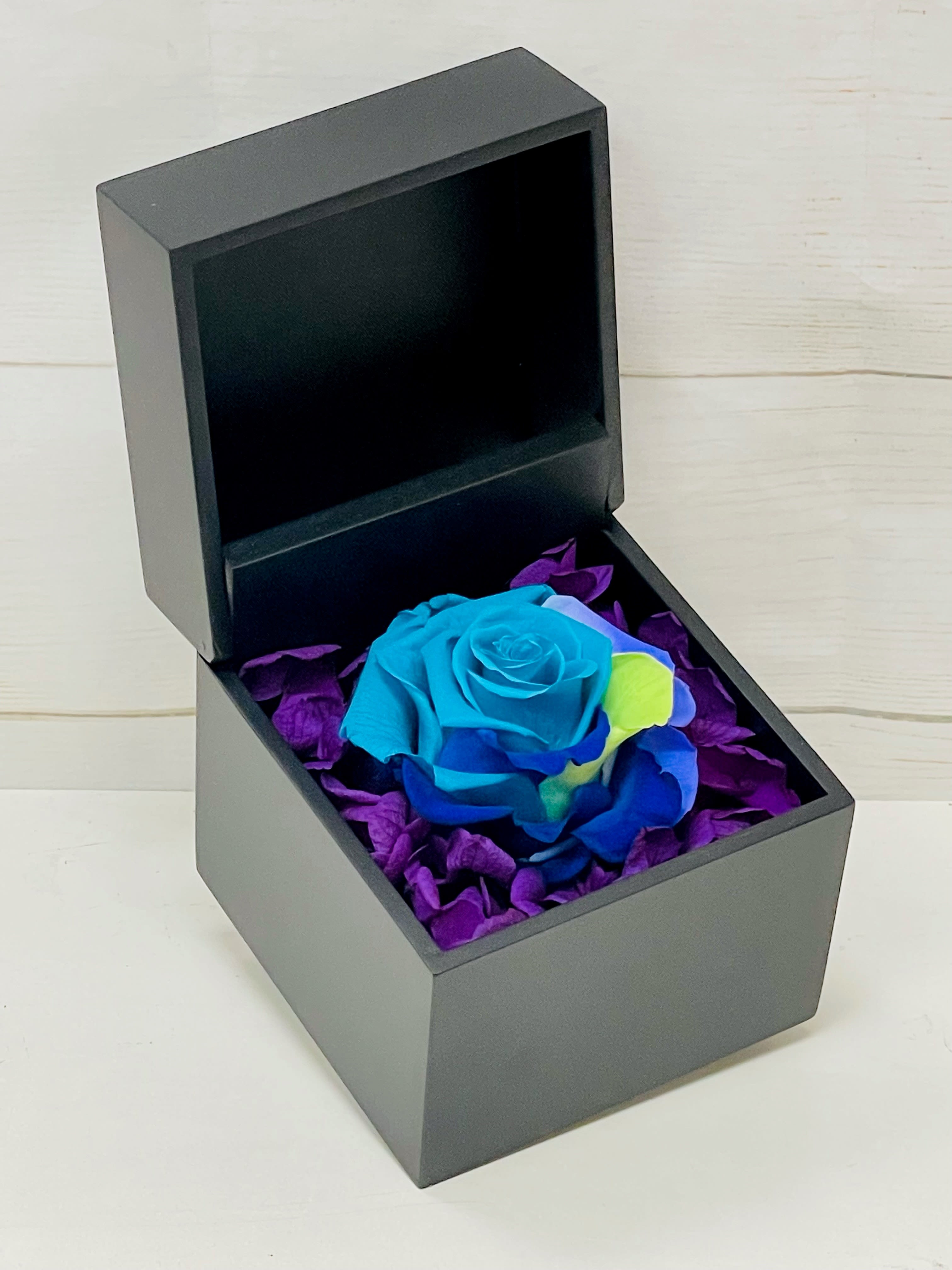 New Item: Real Preserved Rose Box (Blue) New Item: Real Preserved Rose Box (Blue) - Enjoy our incredible new preserved roses! With patented technology, these stunning roses are designed to last up to a year, allowing you to appreciate their beauty for an extended period. This particular product features a Blue rose. Key Features: Long-Lasting Beauty: Using advanced patented technology, this preserved red rose maintains its natural appearance and vibrant color for up to a year. Elegant Design: The classic red rose symbolizes love and admiration, making it a perfect gift or decorative piece. Low Maintenance: No watering or special care required, simply enjoy the beauty of the rose for an entire year. Versatile Use: Ideal for home decor, office spaces, special occasions, or as a thoughtful gift for loved ones. High-Quality Preservation: Ensures the rose retains its natural softness, shape, and color, providing a realistic and lasting impression. Experience the timeless elegance of our Preserved Blue Rose, a perfect blend of natural beauty and innovative technology that brings joy and sophistication to any setting.