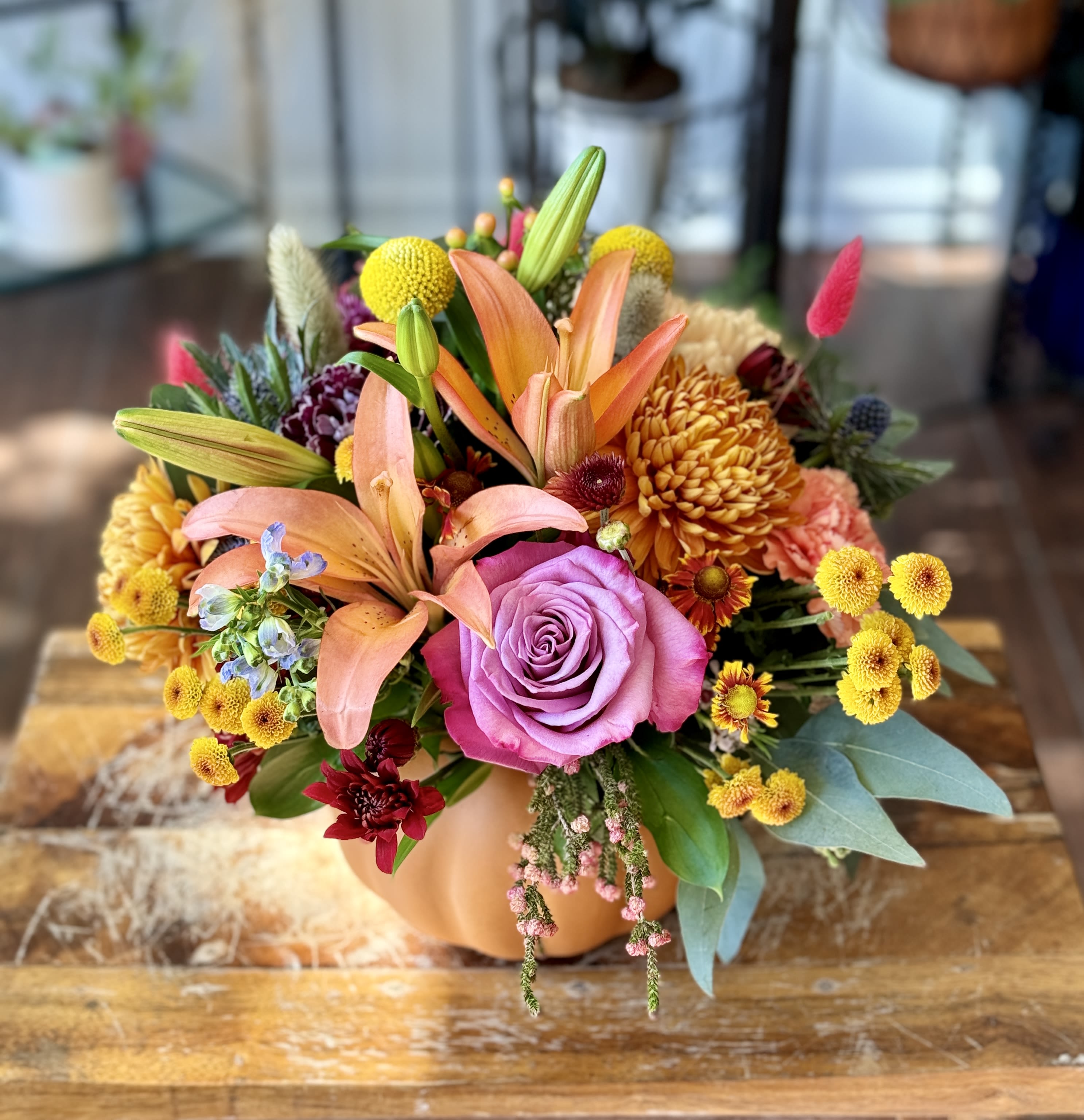 Anna - Perfect autumn centerpiece in a pumpkin with Lilies, various mums and berries.