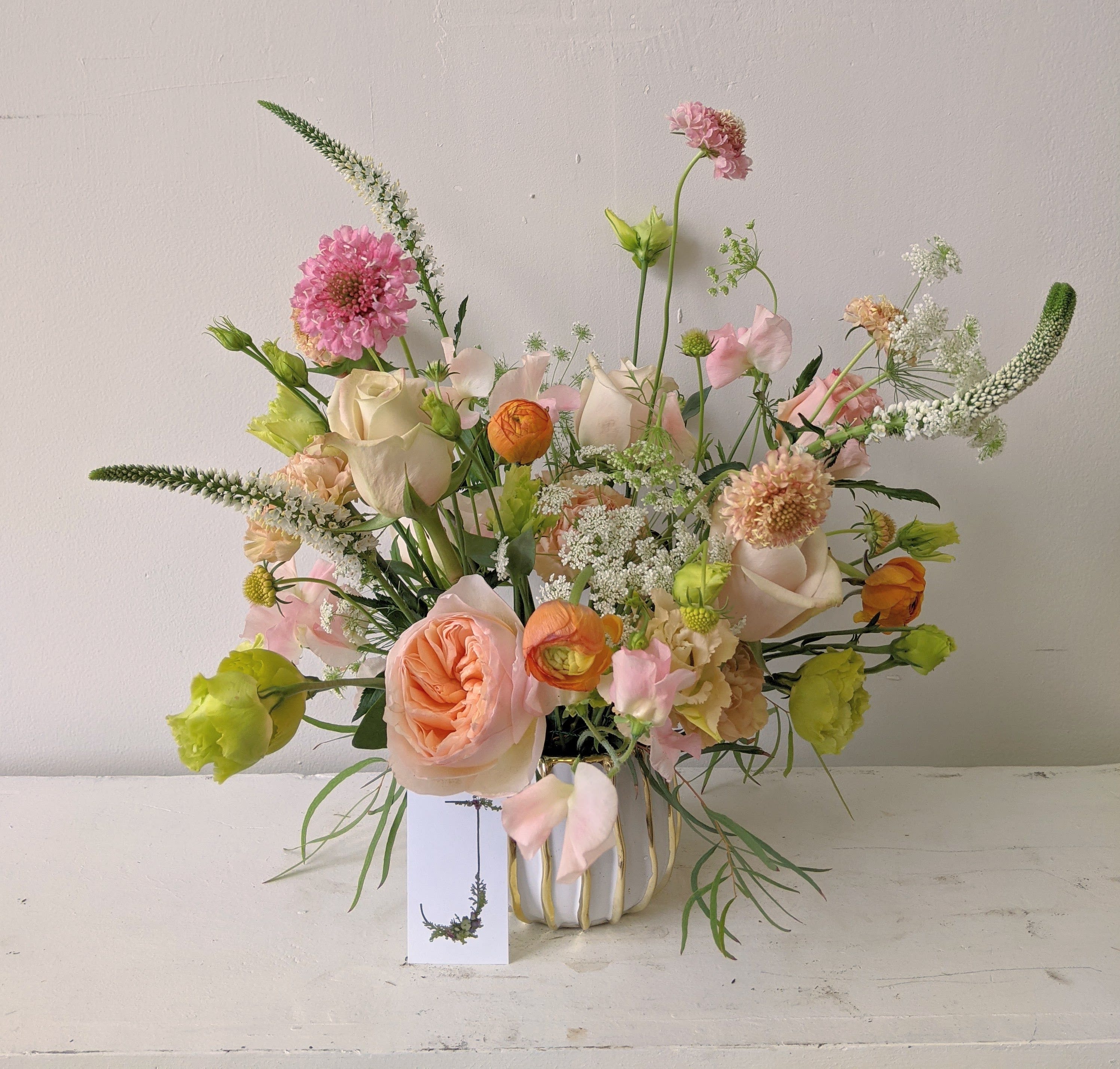 Summer Peaches - A light and airy arrangement to remind you of the sweet summer peaches. Comes in a white and gold ceramic vase. 