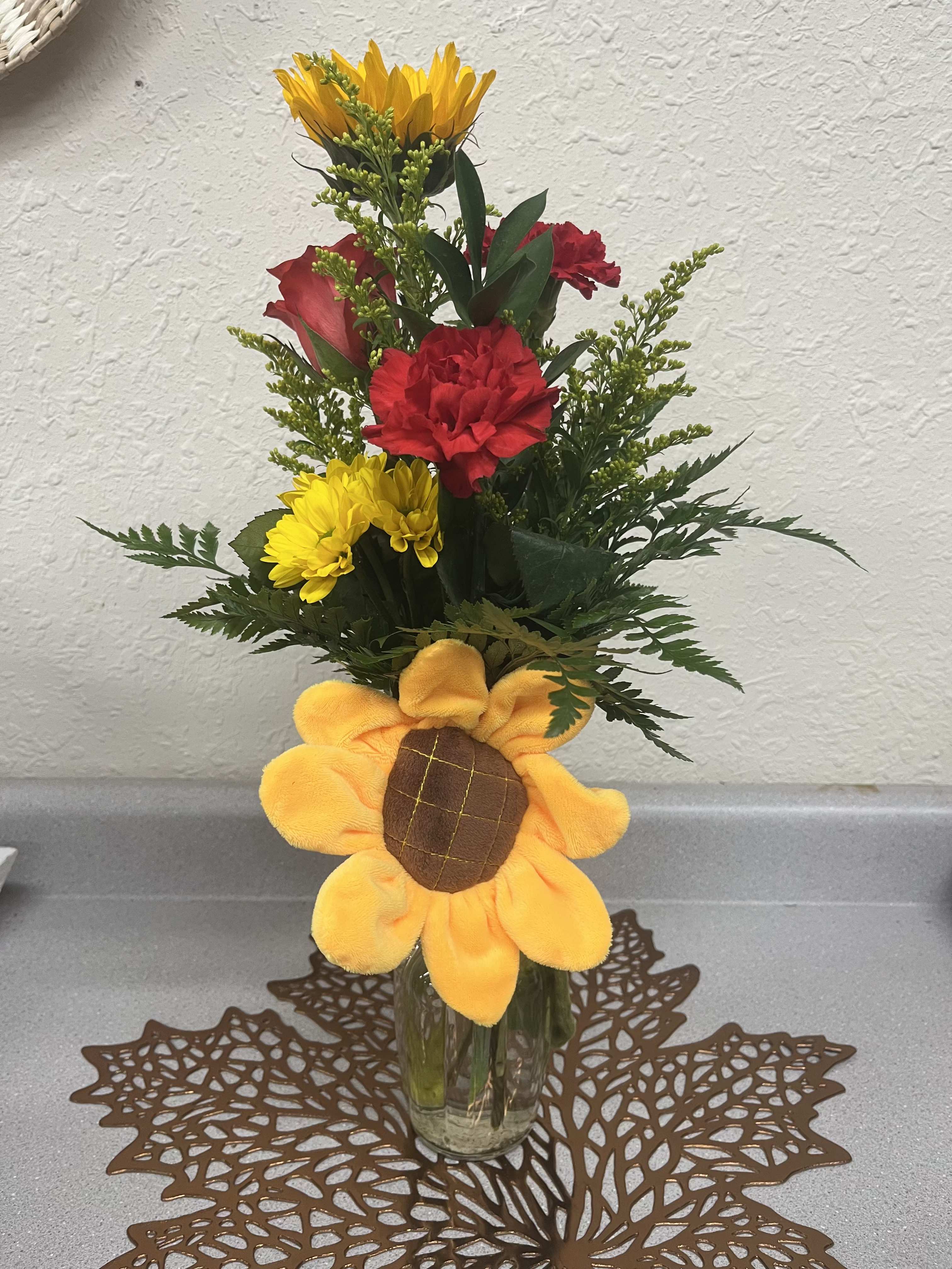 Sunny Days - Need something sweet and simple? This fun little falls arrangement is sure to brighten anyone's day! It features a sunflower with carnations, daisies, and a rose with an adorable sunflower vase hugger. 