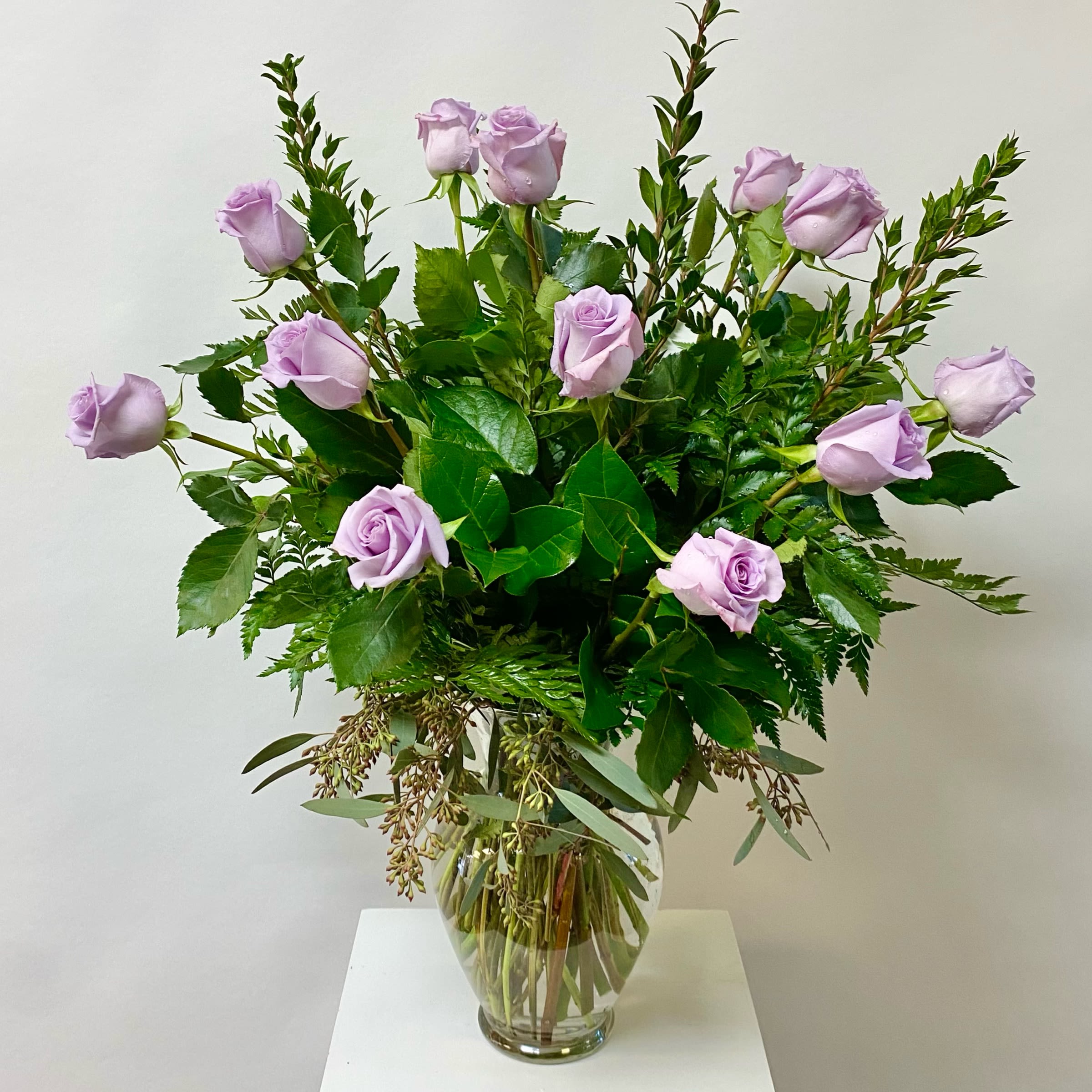 Dozen Lavender Roses Dozen Lavender Roses - Lavender Roses with Greenery Arranged in a Glass Vase.