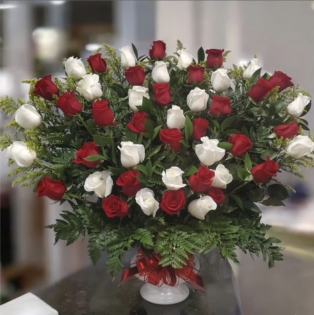 Pacto de Amor - Este es un arreglo espectacular, muy grande y con el contraste clásico de rosas rojas y blancas. Es ideal para declaraciones de amor, aniversarios importantes, o como una pieza central impresionante.