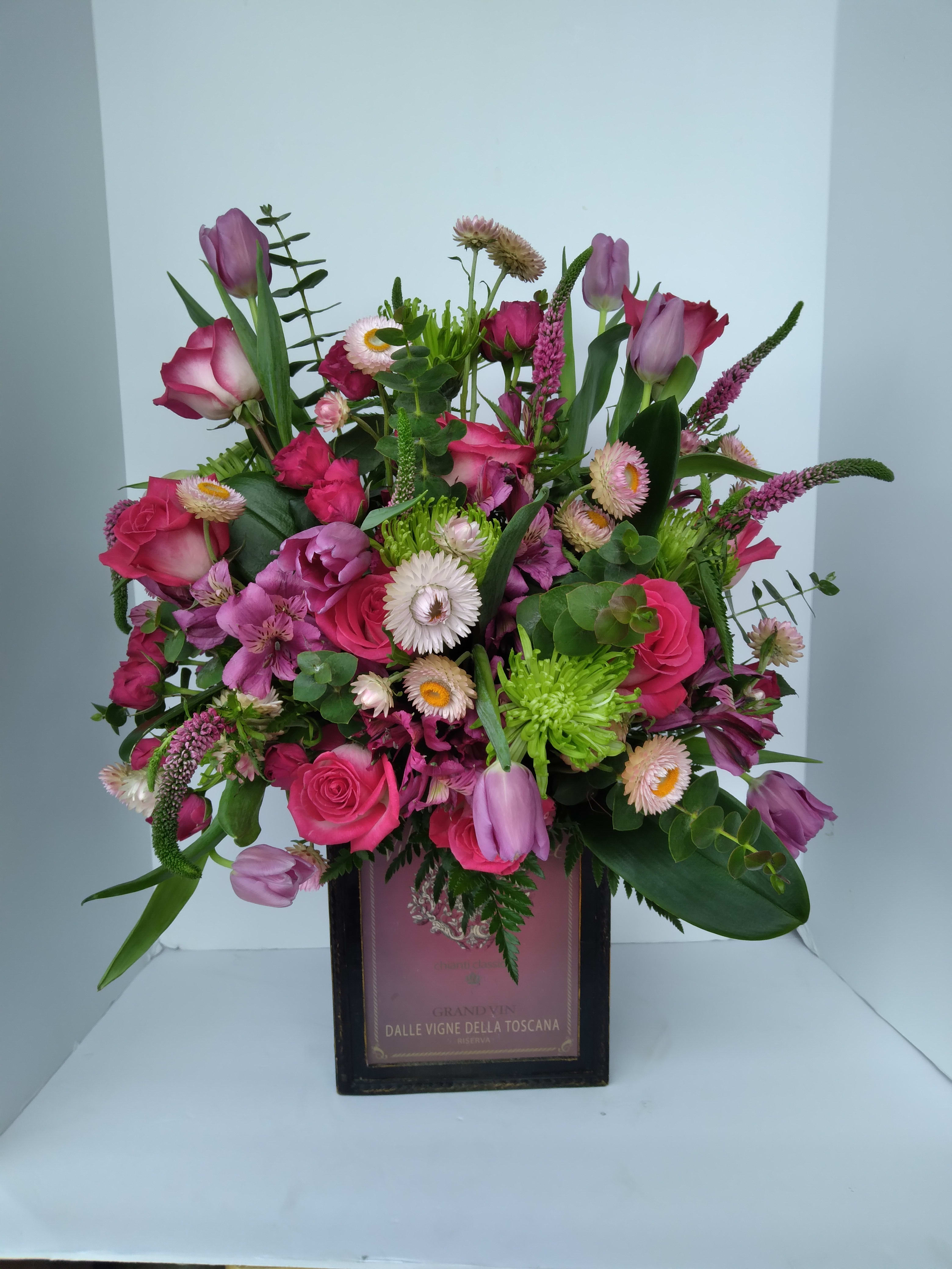 PINK WINE - ASSORTED PINK SEASONAL BLOOMS IN A CUSTOM WINE BOX.