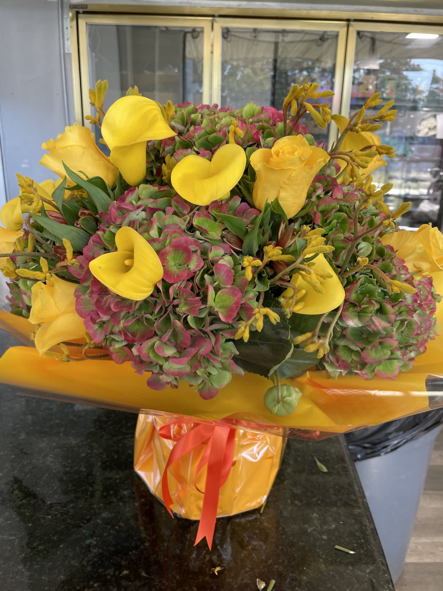 Fall in Love with Fall - Med- Large arrangement - Dutch Bi-Colored Hydrangea , Yellow Roses , Yellow Callas and Greens and Alstroemeria to compliment, arranged in a Vase.  Standing about 20 inches tall and 17 inches Wide,