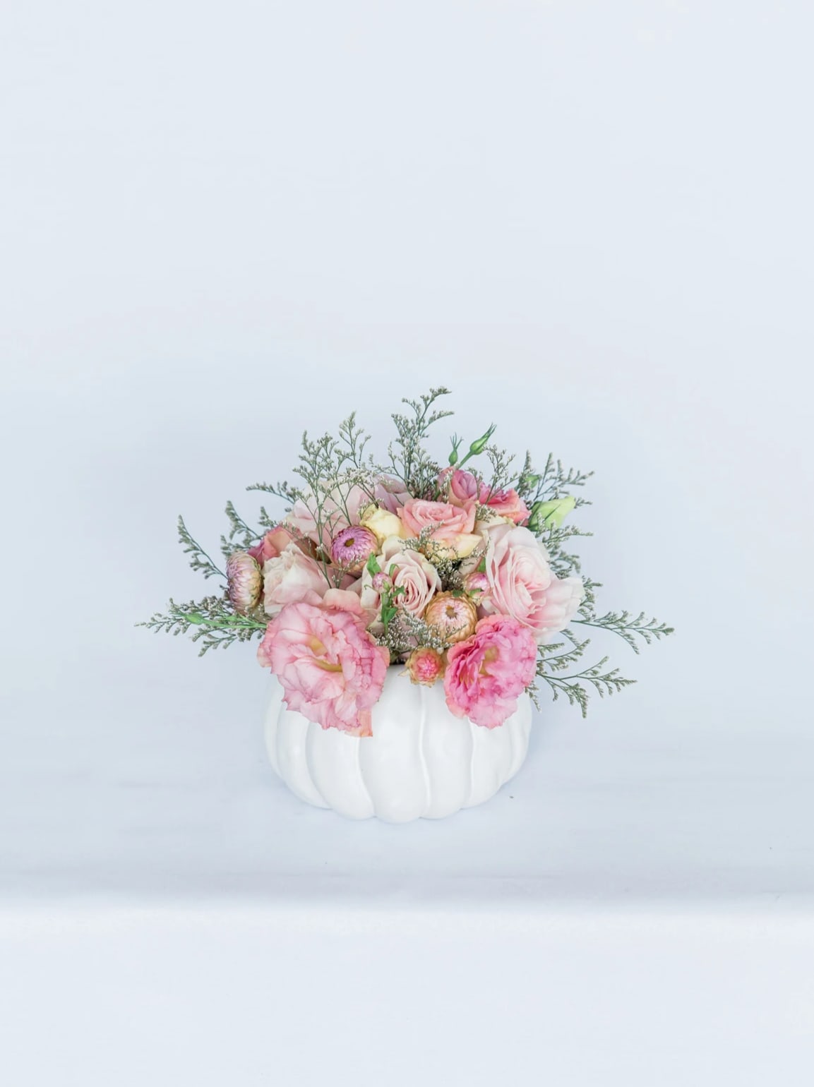Sweater Weather - Celebrate the changing of the seasons with our new Fall Collection! Snuggle up and brighten anyone’s space by sending them the Sweater Weather, which comes arranged with a beautiful mix of pastel pink premium blooms and textures, all cozily designed in one of our hand-picked designer pumpkin vases.**  Pictured [DELUXE]  *Some items in this arrangement must be special ordered, please allow 1-2 weeks notice to allow time for arrival of special items, otherwise, substitutions will occur.*  **While supplies last. Vase will be substituted with another designer vase once the pumpkin vase is out of stock. Please contact the studio directly for any questions.