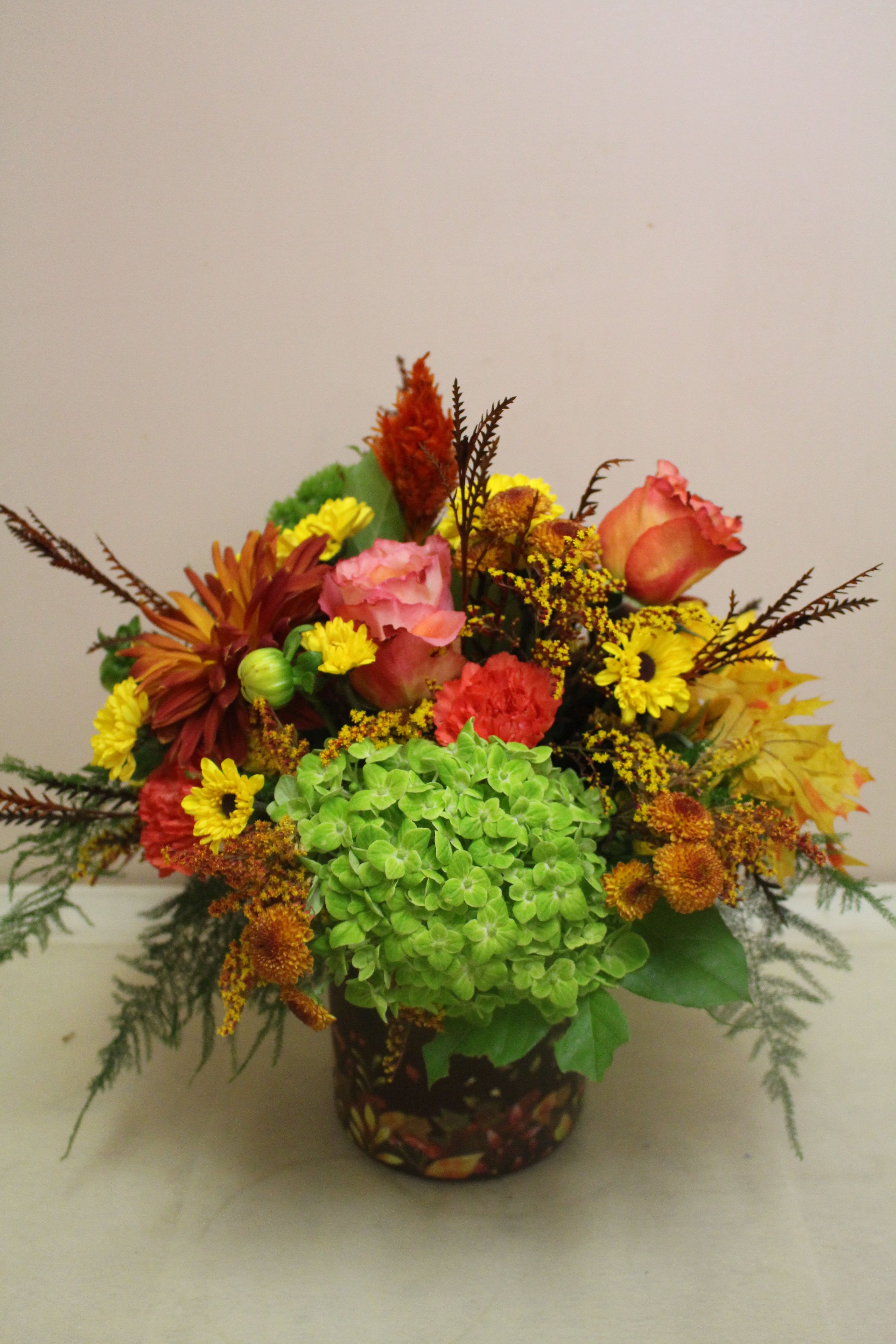 Falling leaves - A crisp autumn arrangement of flowers sits in a vase of fall colors, bringing the outdoors in.