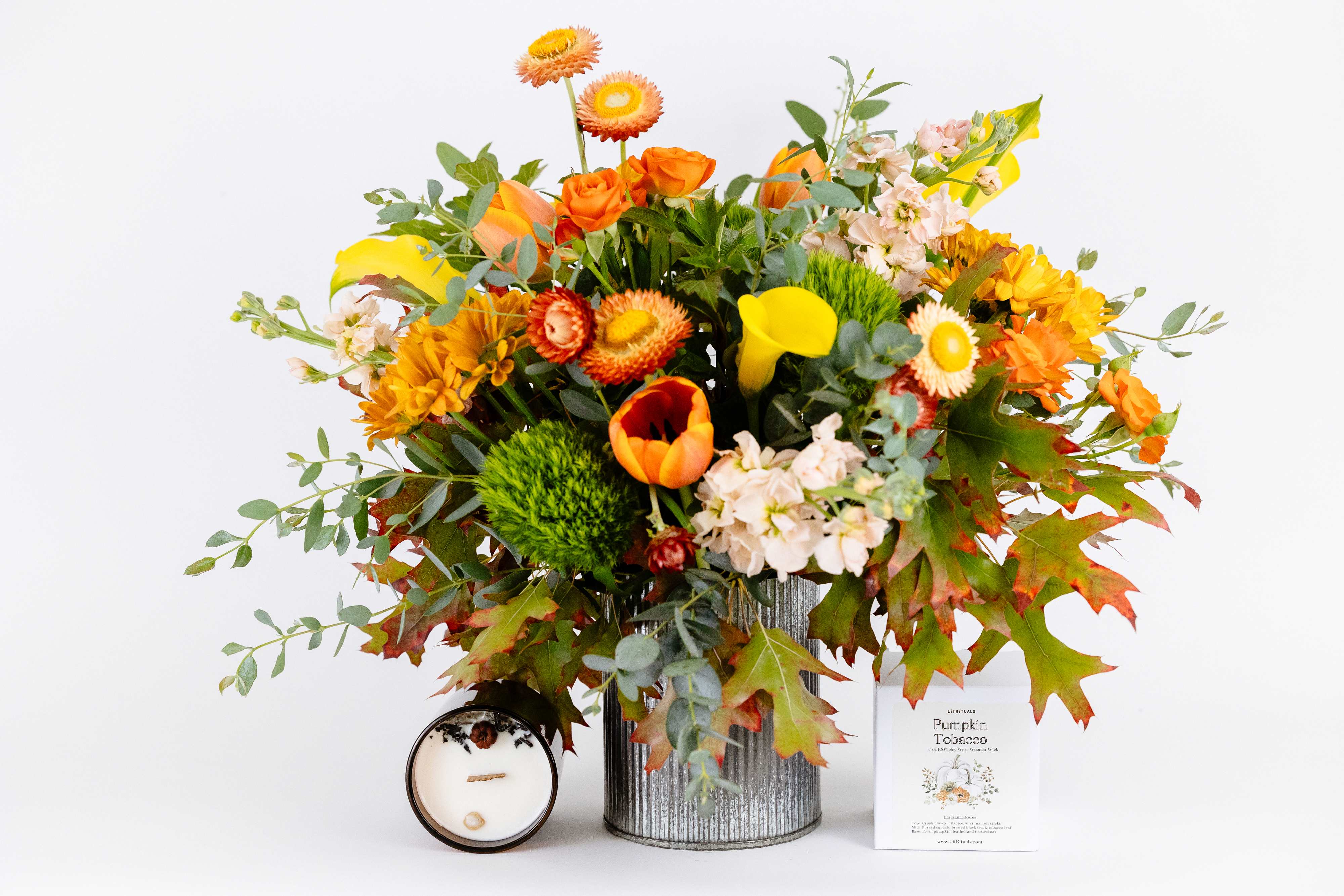 Autumn Skies  - This autumn-forward arrangement includes calla lilies, tulips, and stock. Perfect for any table to warm up those crisp fall days. A Pumpkin Tobacco candle is included to enjoy alongside your flowers filling your house with a classic smokey pumpkin-y goodness.   SIZE: The STANDARD flower arrangement is approximately 15” height and 15” width.  ALLERGY ADVICE: This design is low in pollen and has a moderate fragrance.  Ready to bring floral beauty into someone’s world with our autumn-inspired flower arrangement? Order this gift online now or give us a call on (415) 752-2060 if you have a question or special request.