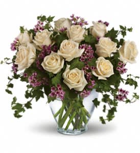 Victorian Romance - Romance blossoms beautifully within this elegant bouquet. The serenity and innocence of cream-colored roses is in delightful juxtaposition with lavender waxflower and fresh ivy greens. It's as romantic as a stroll through the English countryside.  A dozen crème roses, lavender waxflower and ivy are perfectly arranged in a serenity glass vase.  Approximately 17&quot; W x 15&quot; H  Orientation: All-Around      As Shown : T69-1A     Deluxe : T69-1B     Premium : T69-1C 