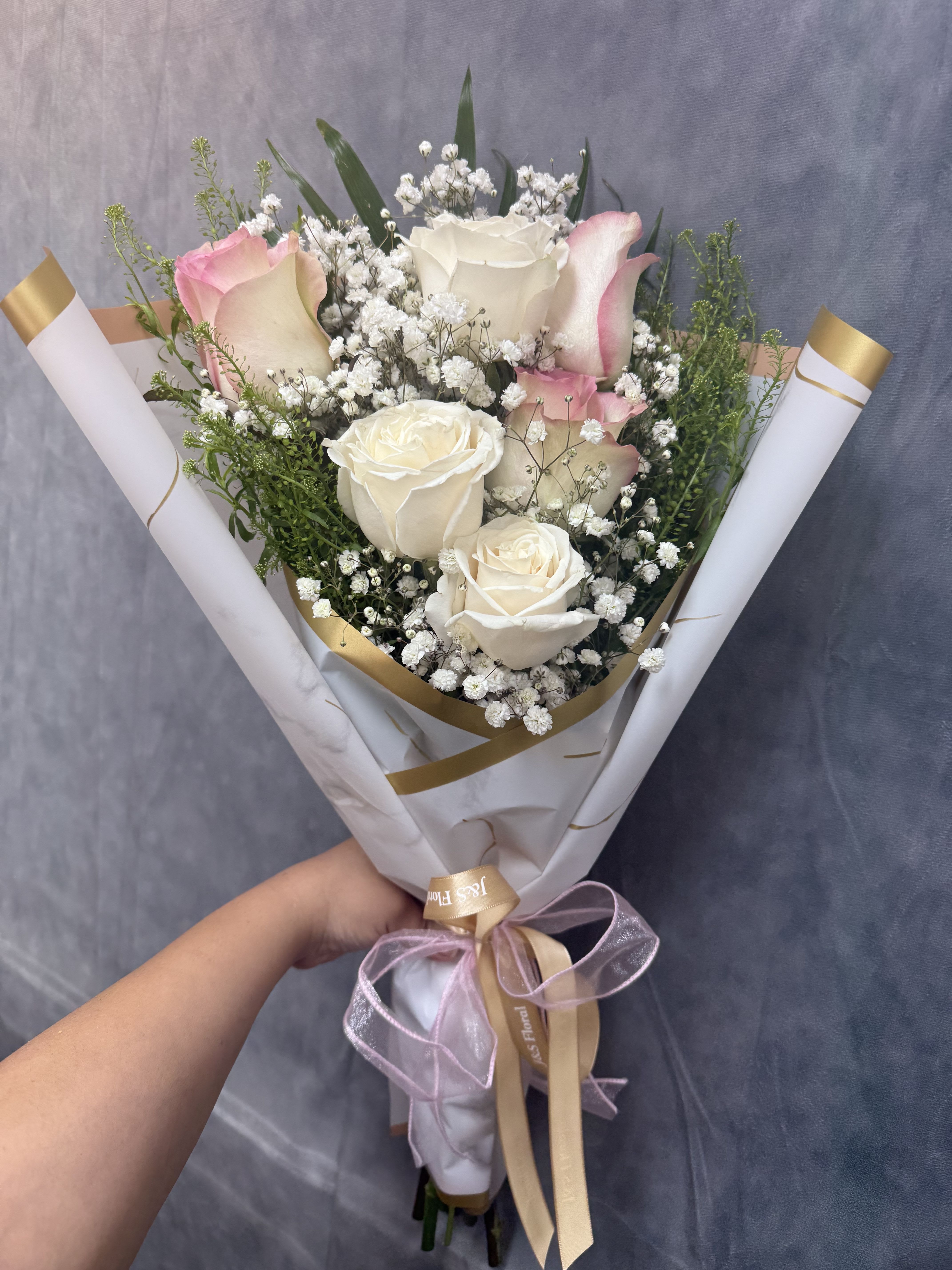 Pink and white layered bouquet Pink and white layered bouquet - Half dozen layered Pink and white roses with baby’s breath wrapped in elegance perfect for celebrating milestones