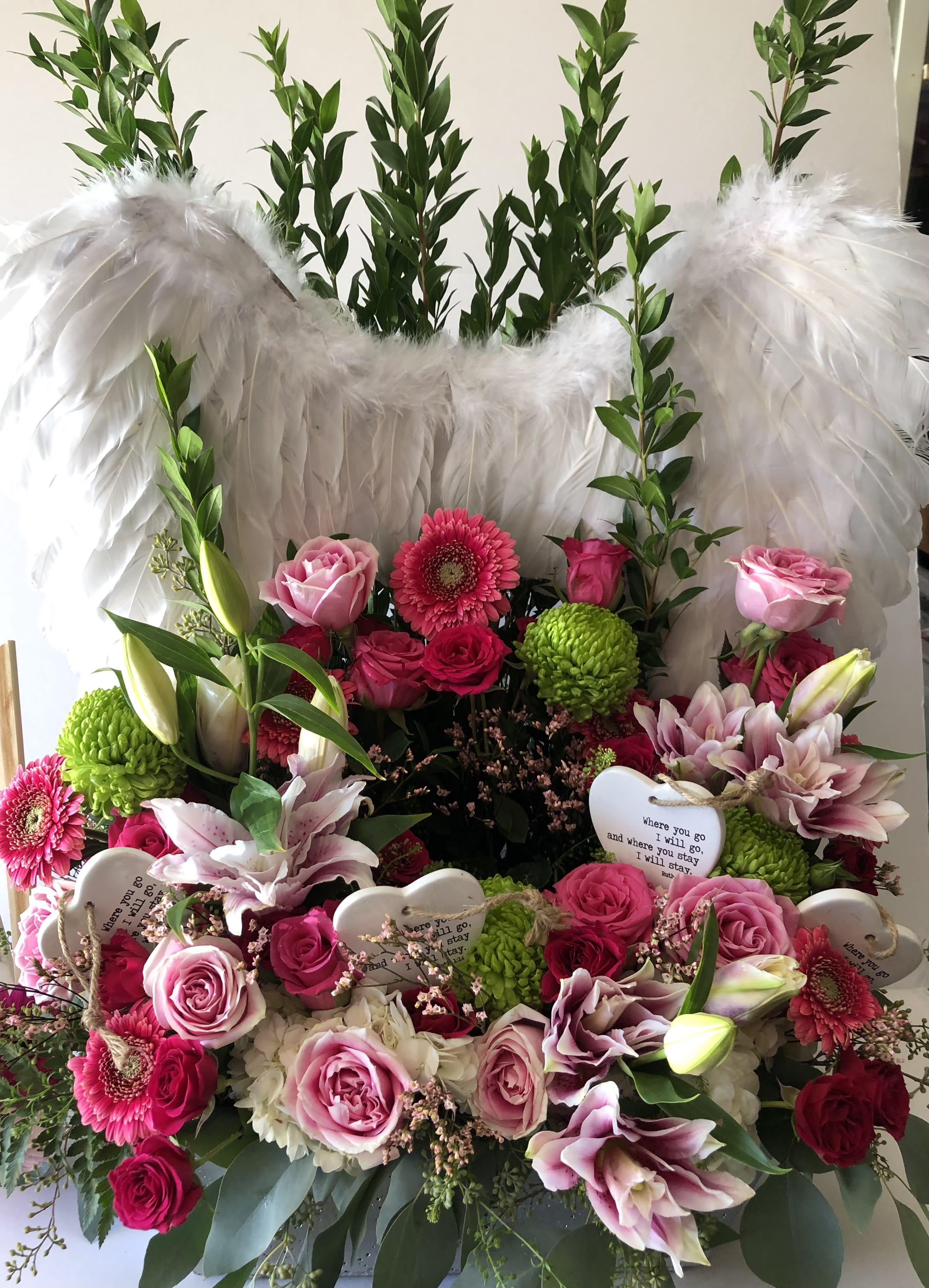 Winged Remem - These angel wings surround the urn and are filled with pastel pink seasonal blooms. A lovely way to honor someone.