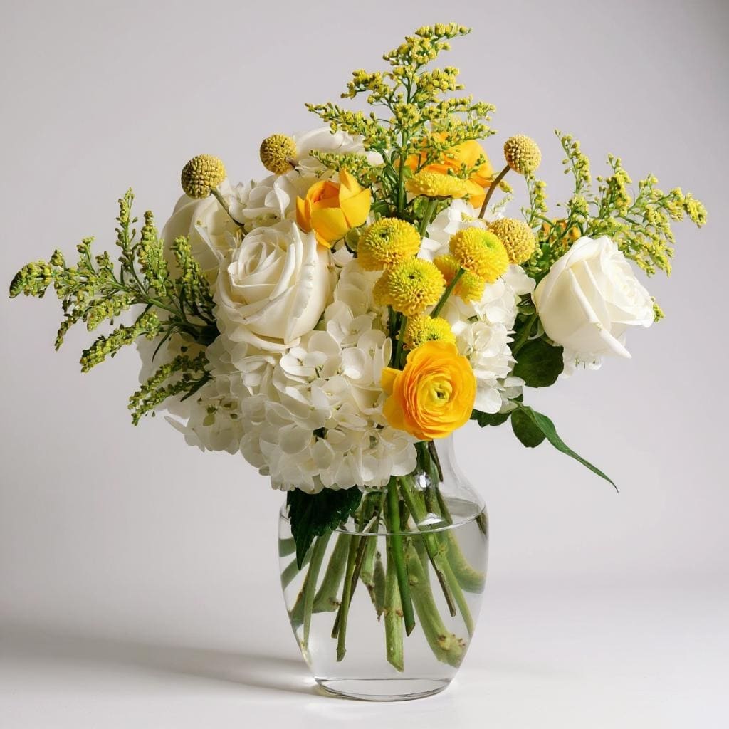 Little Miss Sunshine - Say hello to happiness! Little Miss Sunshine is a joyful burst of bright yellow blooms designed to bring instant smiles. With sunny yellow ranunculus, cheerful button mums, fun and funky billy balls, and fluffy white hydrangeas, this arrangement is pure sunshine in a vase. It’s bubbly, vibrant, and bursting with personality — the perfect way to brighten someone’s day, celebrate good vibes, or just sprinkle a little sunshine wherever it goes!   Vase subject to change