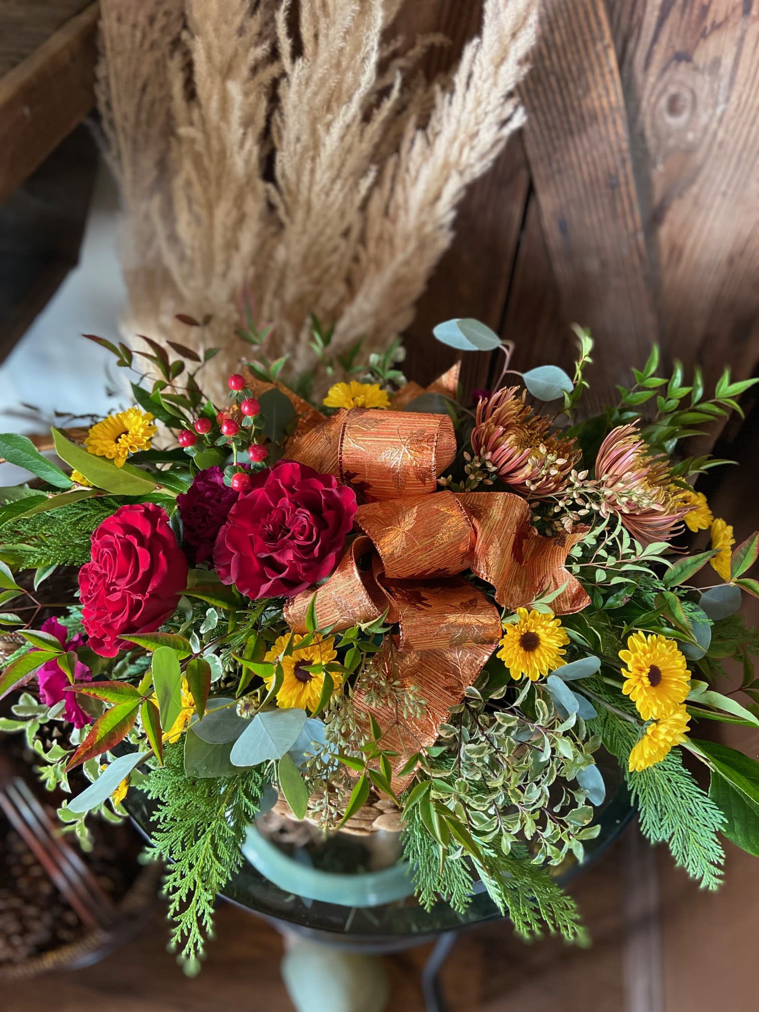 Cheery Thanksgiving Centerpiece  Cheery Thanksgiving Centerpiece  - Classic Style Thanksgiving Centerpiece with Copper Leaf Ribbon.  Sure to Finish off the Perfect Table Setting.**Flowers may vary