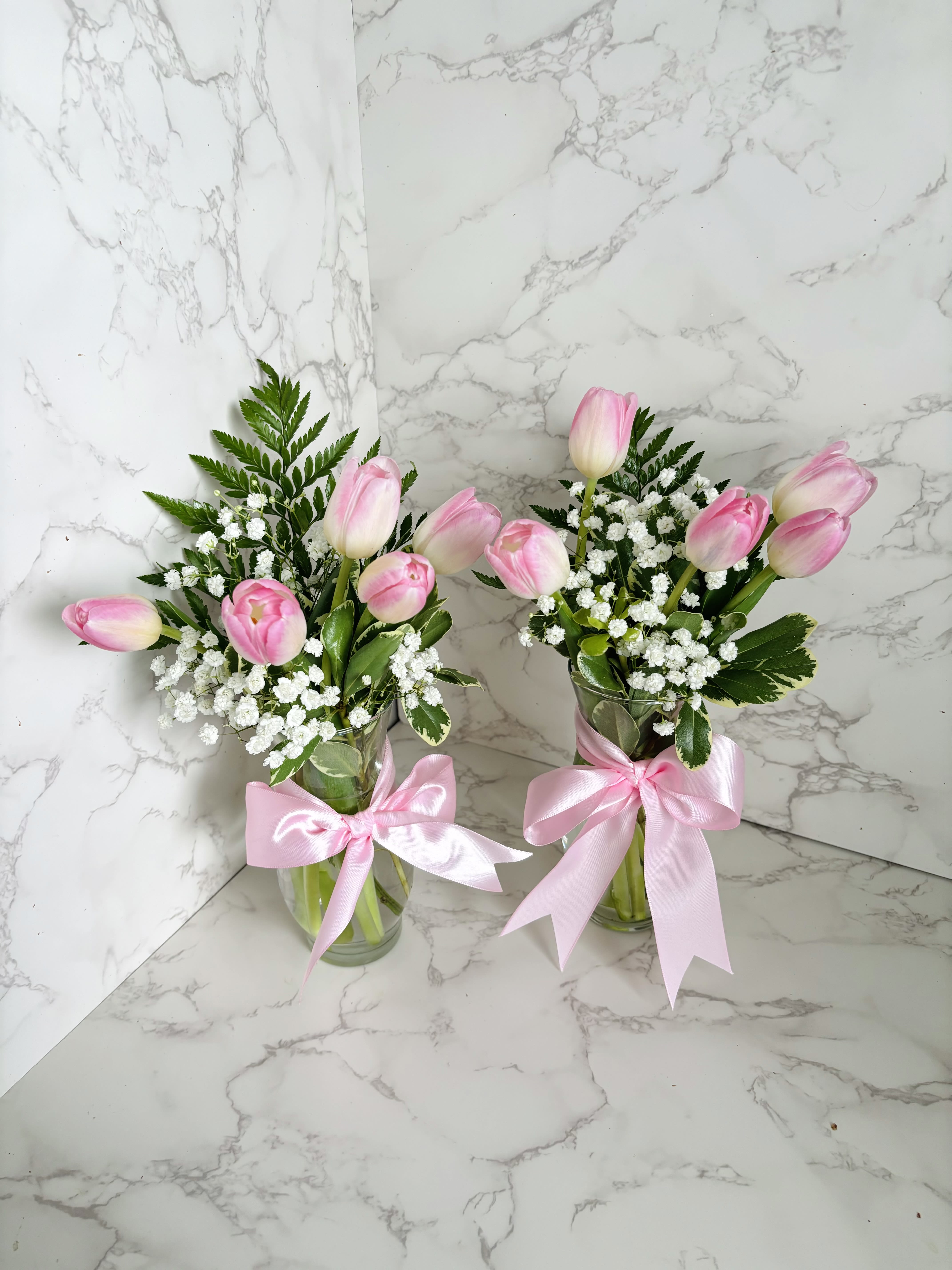 Blushing Tulip Corporate Arrangements (PRICE BASED ON QUANTITY OF 15 OR MORE) - Elegant and uplifting, our Blushing Tulip Corporate Arrangements bring a soft touch of nature into any professional space. Each vase features fresh pink tulips, delicate baby’s breath, and rich greenery, all beautifully tied with a satin ribbon for a polished and refined look. Ideal for office décor, client appreciation, events, or staff recognition, these arrangements create a warm and inviting atmosphere.  Special Offer: Enjoy exclusive quantity discounts on orders of 15 or more—perfect for large events, corporate gifting, or company-wide celebrations.  IF ORDERING LESS THAN 15 PLEASE REFER TO THE &quot;TULIPS&quot; SECTION. PRICING FOR UNDER 15 PIECES IS $20 EACH.  ****COLORS MAY VARY UPON AVAILABILITY BETWEEN, PINK, WHITE, PURPLE, YELLOW****