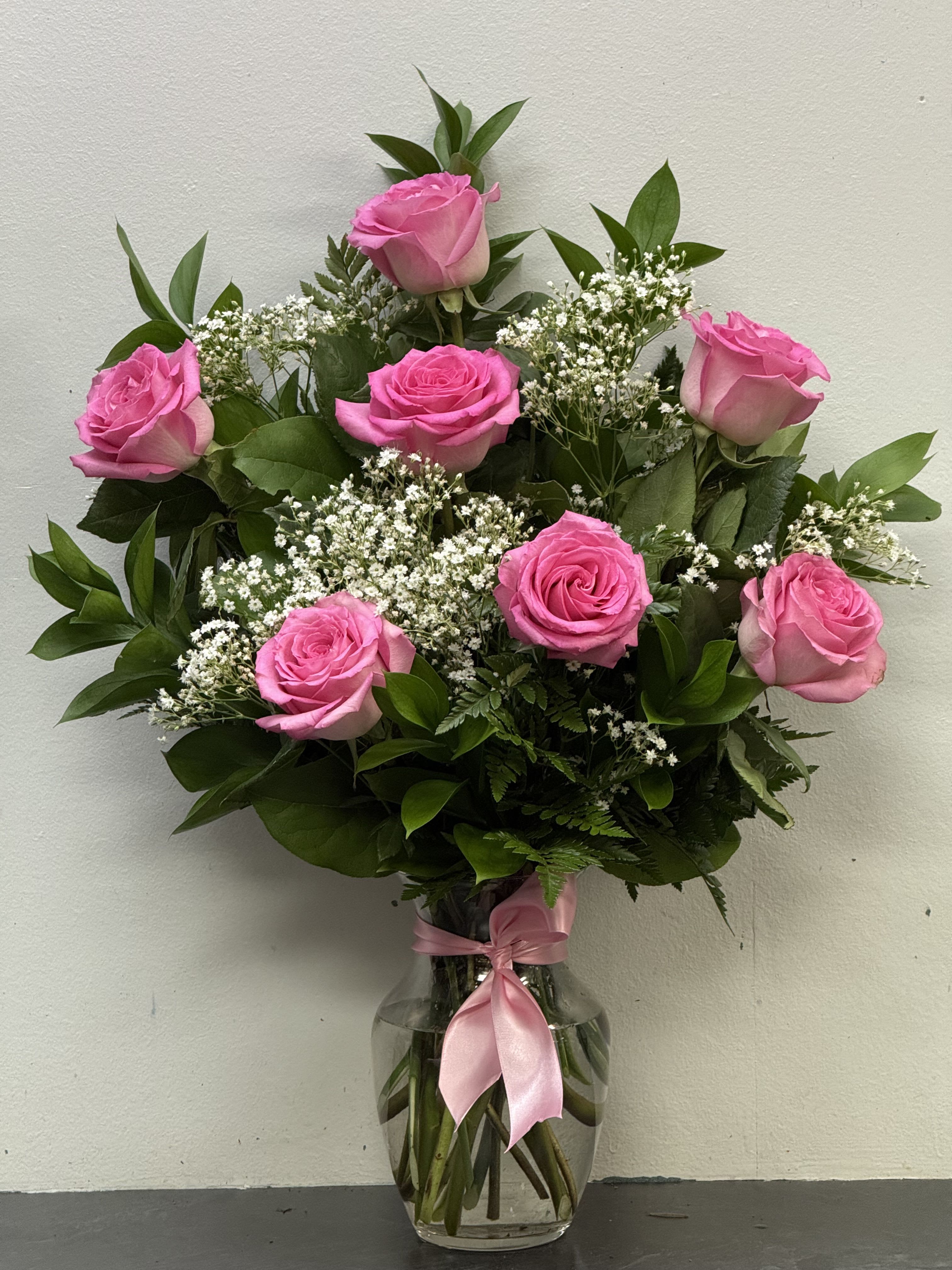 Forever yours-pink  - Soft, romantic, and timeless — this charming arrangement features elegant pink roses beautifully accented with delicate baby’s breath and lush greenery. Hand-arranged in a classic clear glass vase and finished with a matching pink satin bow, it’s a perfect gift to celebrate love, friendship, birthdays, or any special moment that calls for a touch of sweetness and grace.