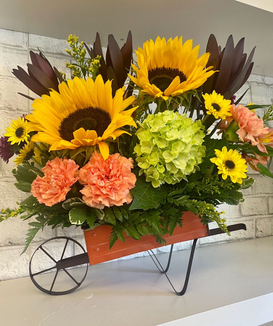 Autumn Delivery - How perfect is this sweet wheelbarrow full of Autumn Blooms. These gorgeous vibrant colors would make a wonderful fall birthday surprise , thinking of you, or the perfect addition on your end table to enjoy as the leaves change colors