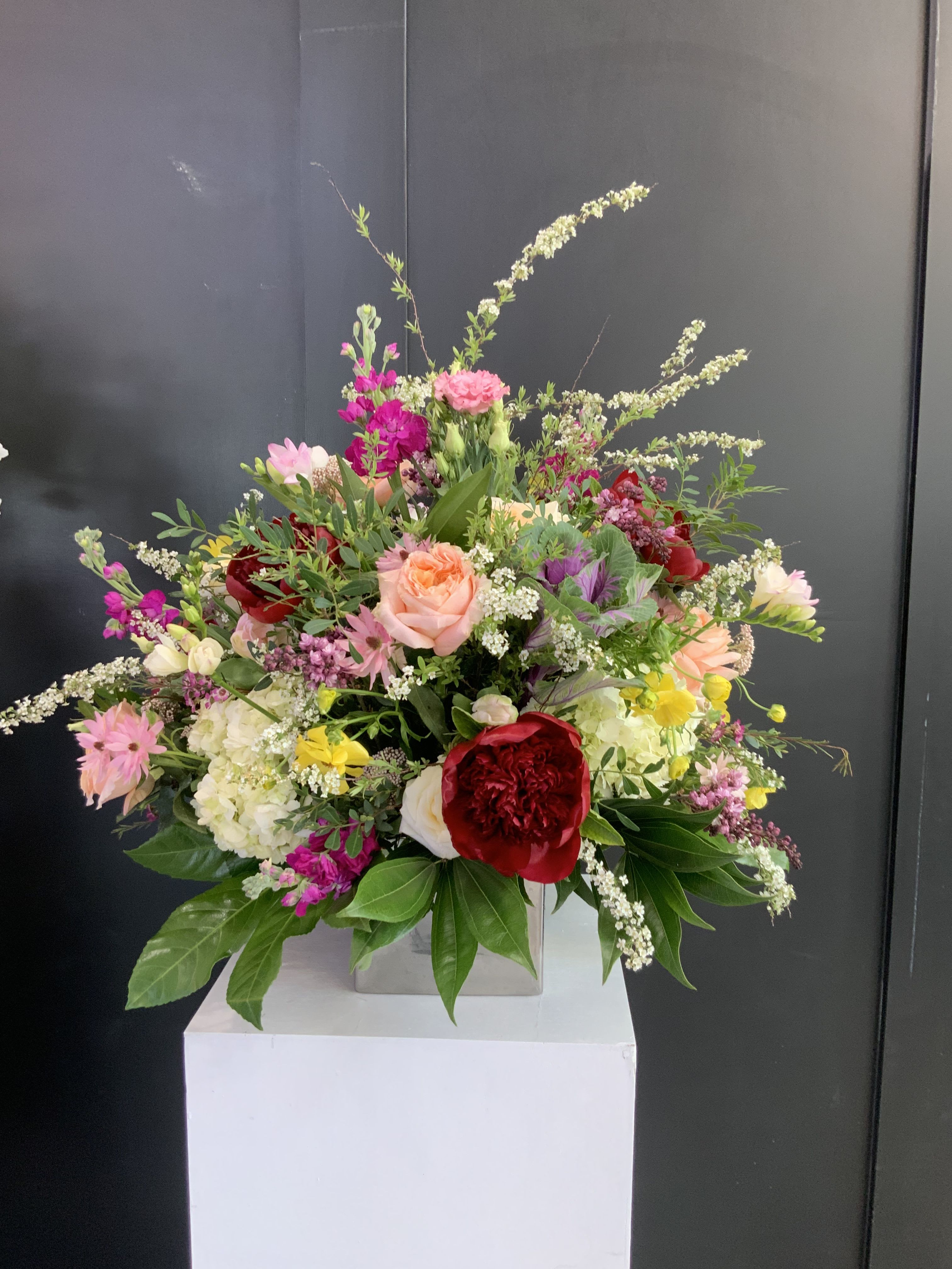 Dazziling Cube  - Delight your loved one with our stunning Dazzling Cube Arrangement. A modern, square glass cube overflows with a vibrant mix of seasonal blooms, creating an eye-catching and contemporary display that's perfect for any occasion. The Dazzling Cube Arrangement offers a unique and stylish way to showcase the beauty of fresh flowers, making it an unforgettable gift for someone special.